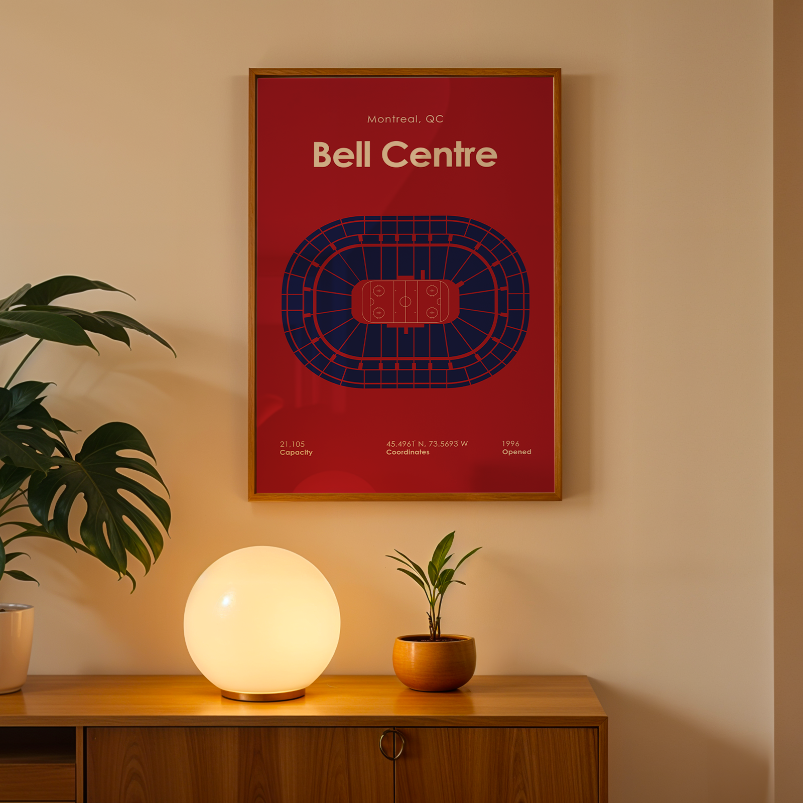 Poster of Bell Centre on a wall above a wooden cabinet with a lamp and plant.