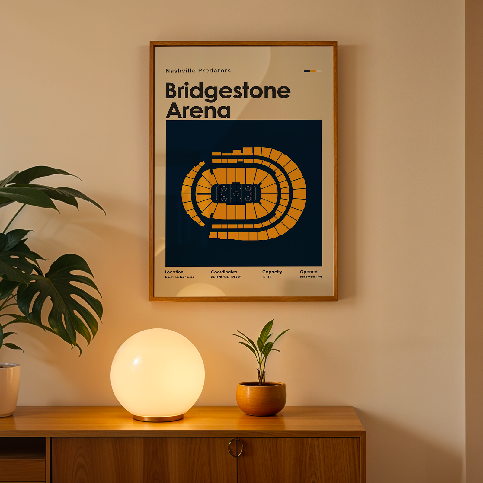 Framed poster of Bridgestone Arena on a wall above a wooden cabinet with decorative items.