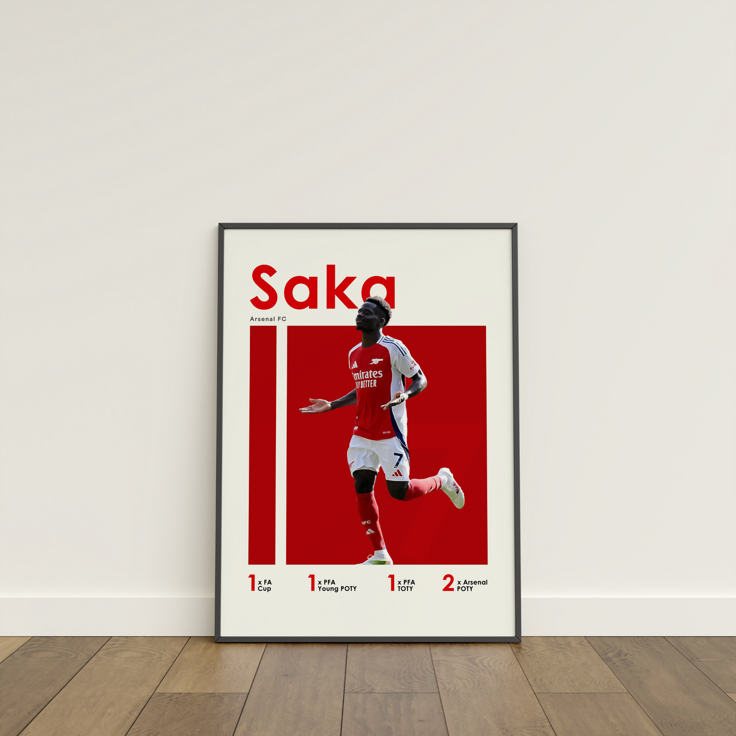 framed poster mockup of soccer player bukayo saka leaning on a white wall