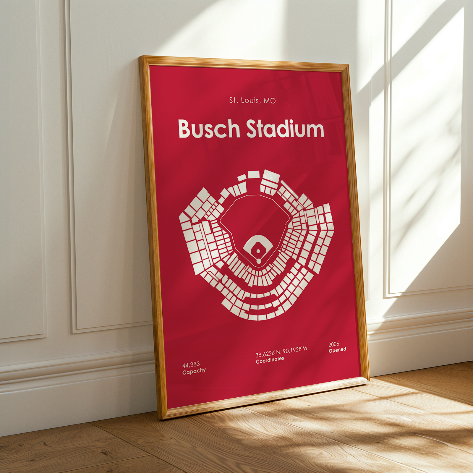 Framed poster of Busch Stadium with red background and white text on a wall.