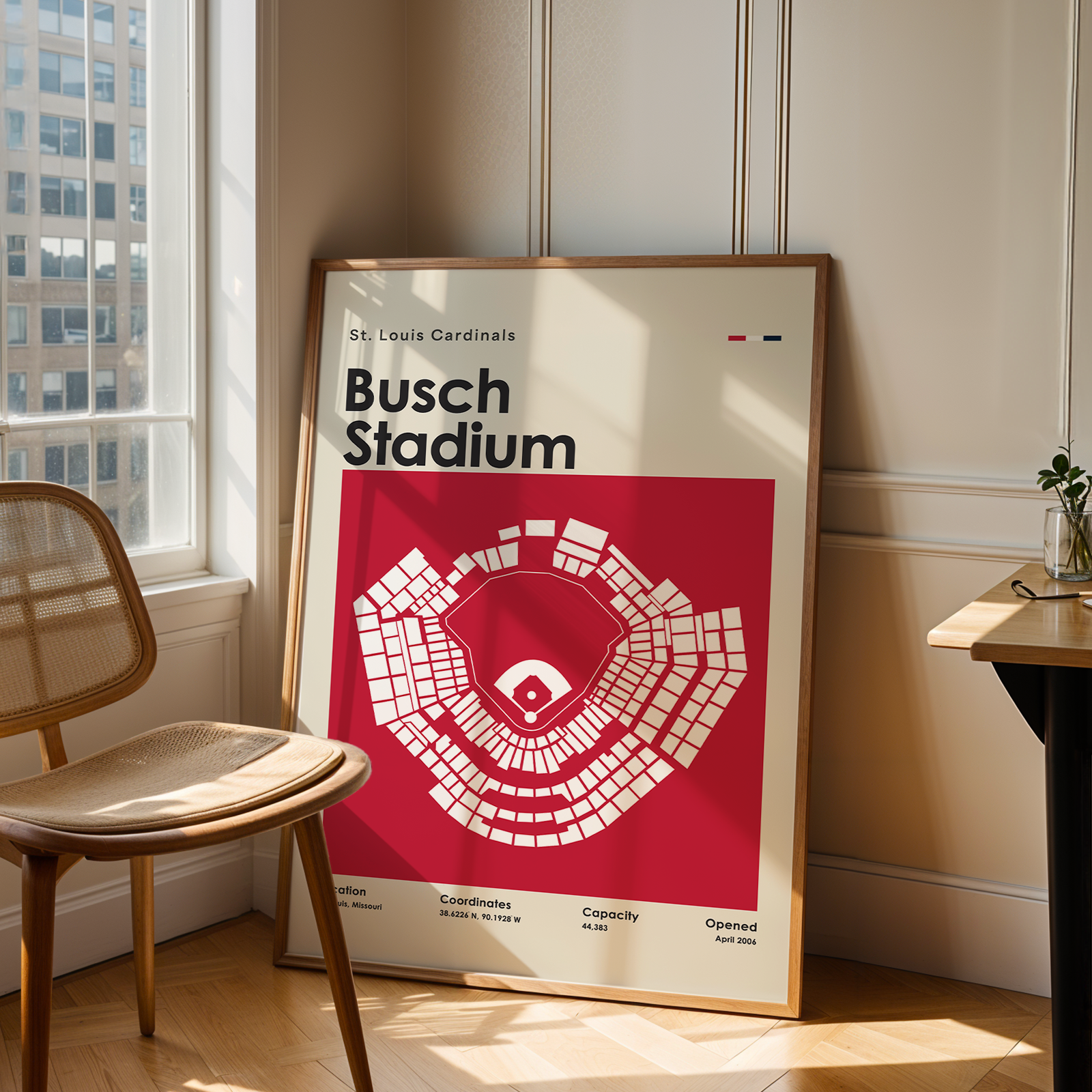 Poster of Busch Stadium in a room with a chair and table.
