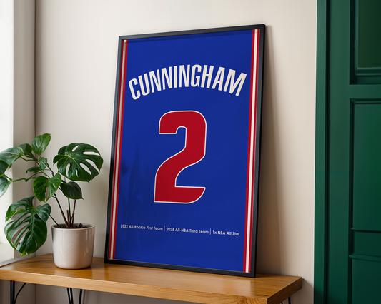 Framed sports jersey with 'Cunningham' and number '2' on a wooden shelf.