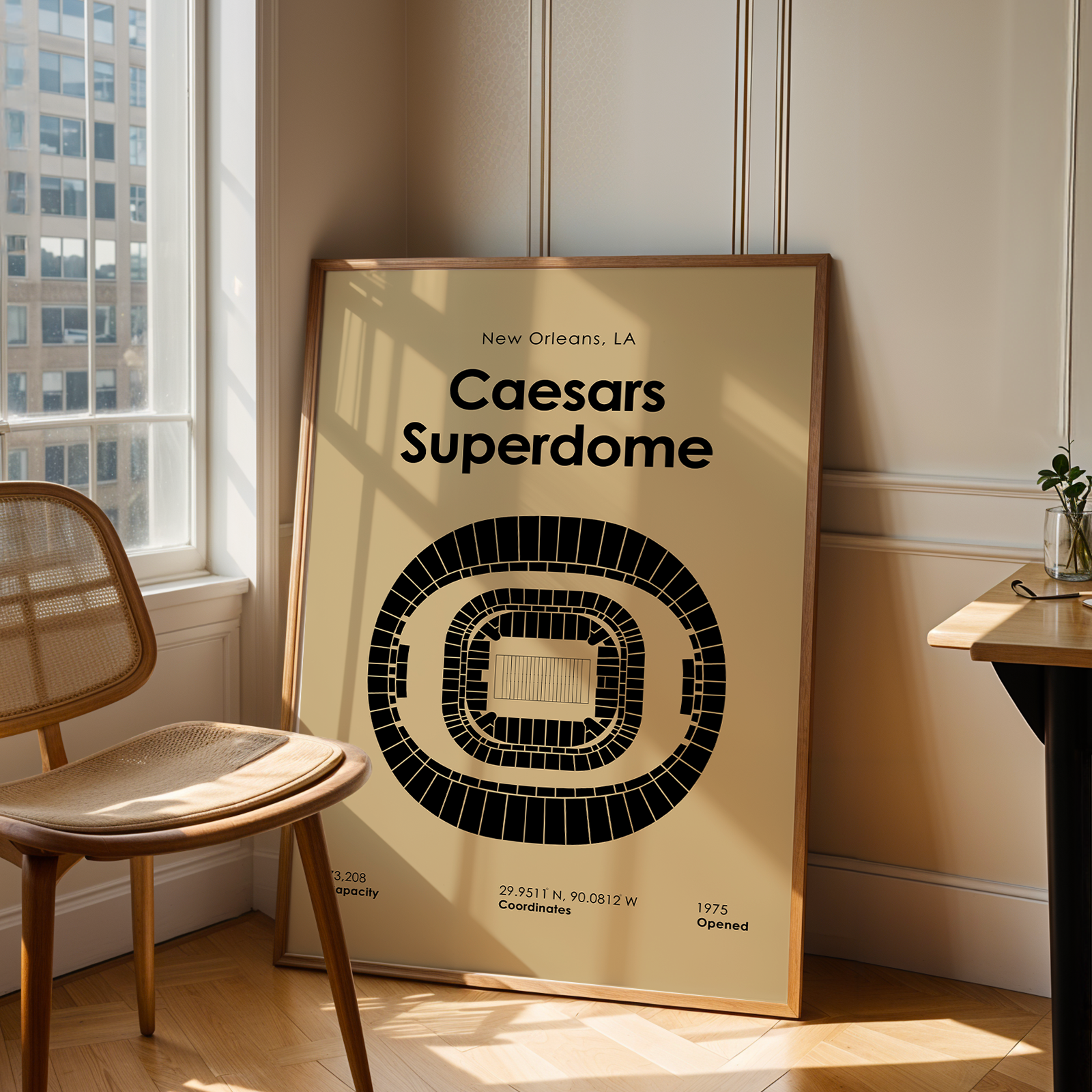 Framed poster of Caesars Superdome in a room with a chair and table.