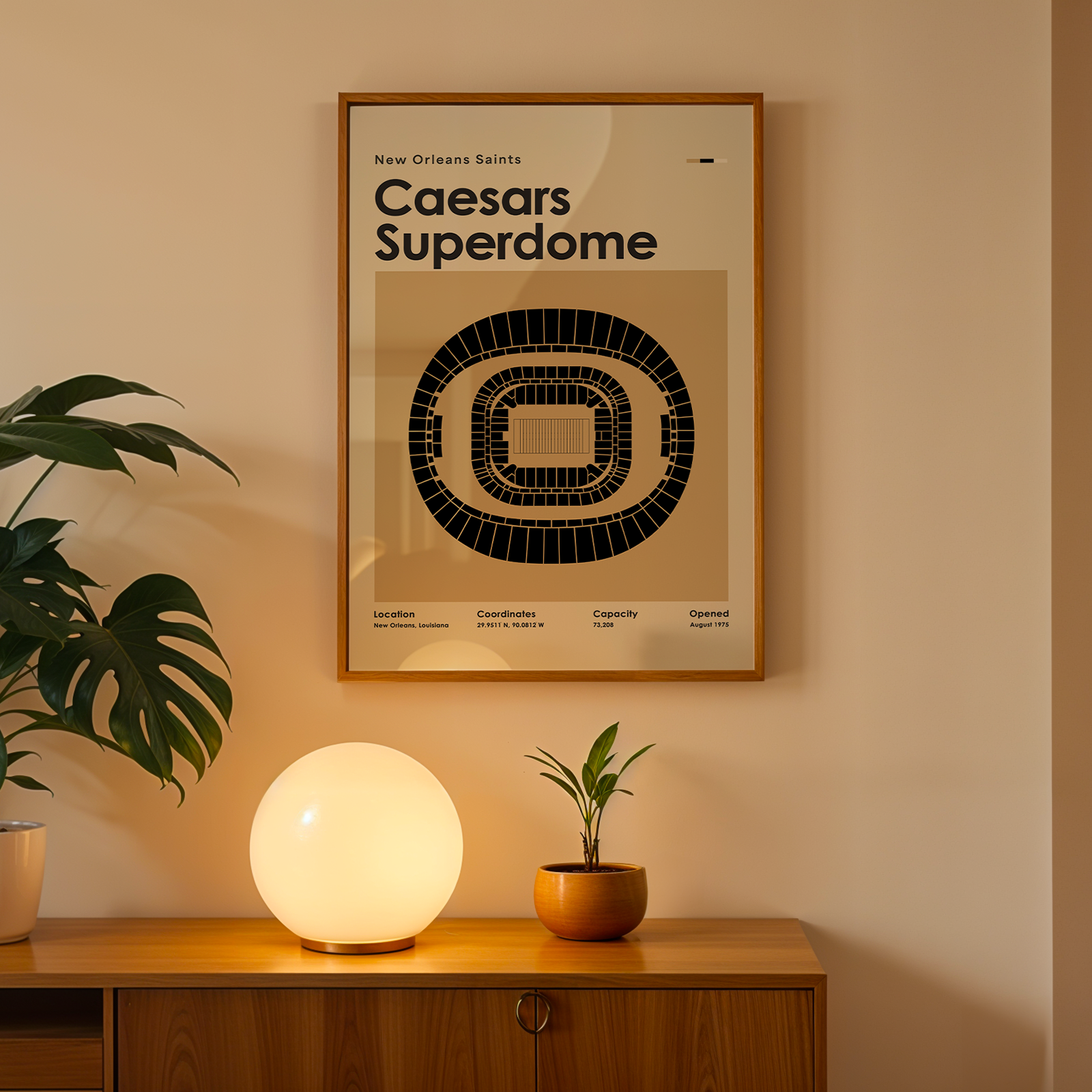 Framed poster of Caesars Superdome on a wall above a wooden cabinet with decorative items.
