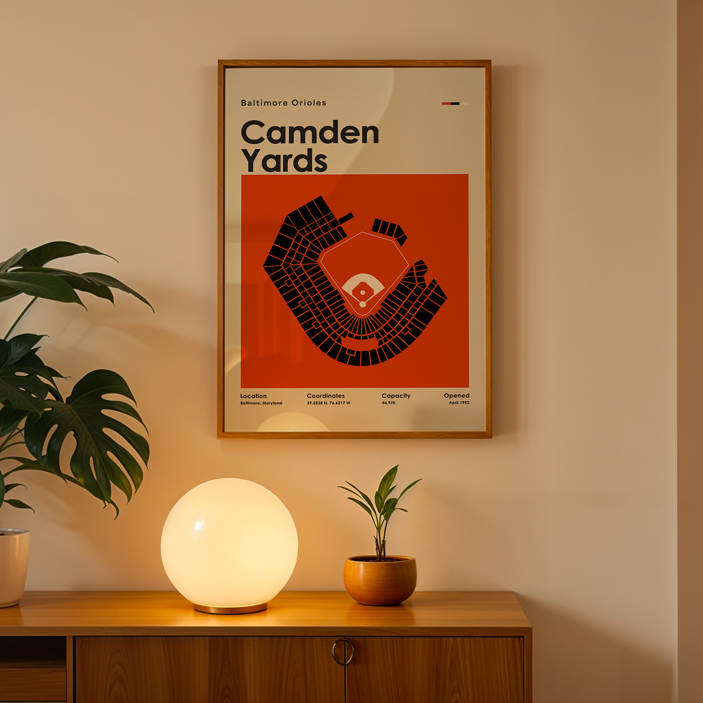 Framed poster of Camden Yards on a wall above a wooden cabinet with decorative items.