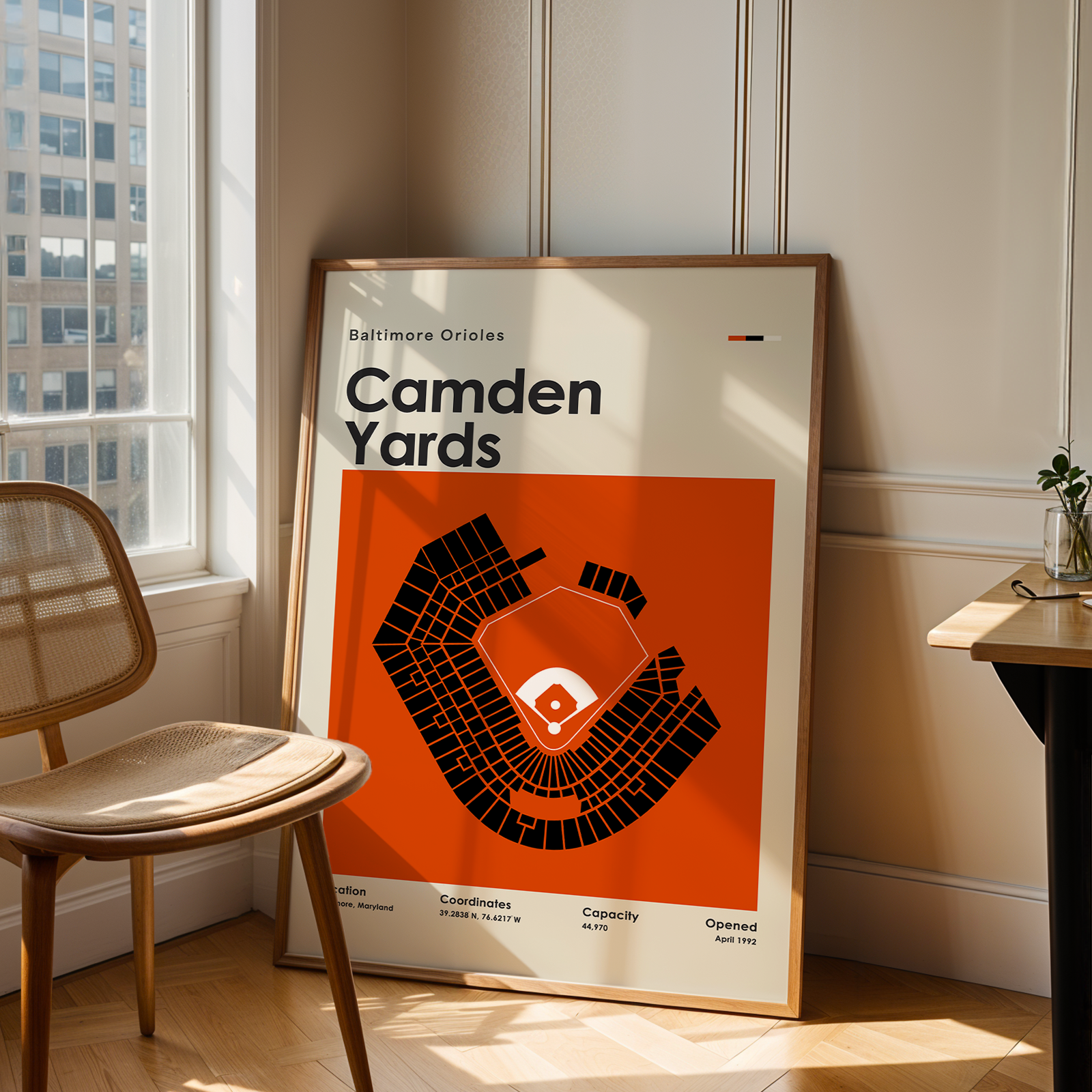 Poster of Camden Yards in a room with a chair and table.
