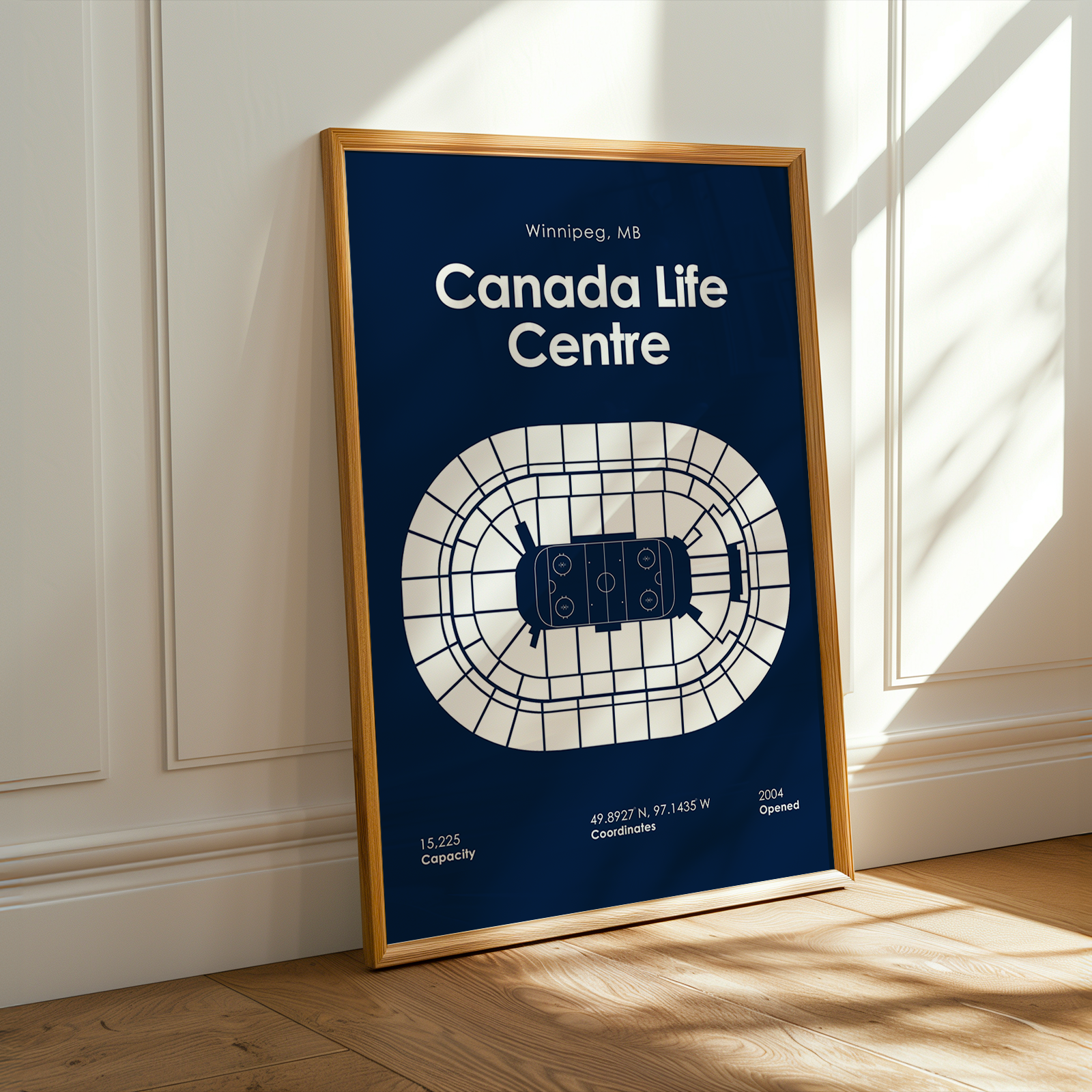 Framed poster of Canada Life Centre with wooden frame on a white wall.
