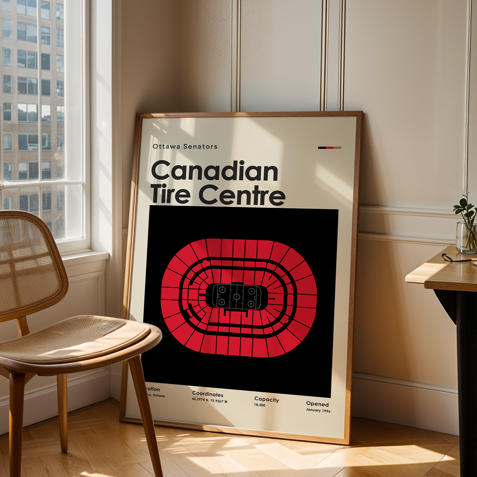 Framed poster of Canadian Tire Centre in a room with a chair and table.