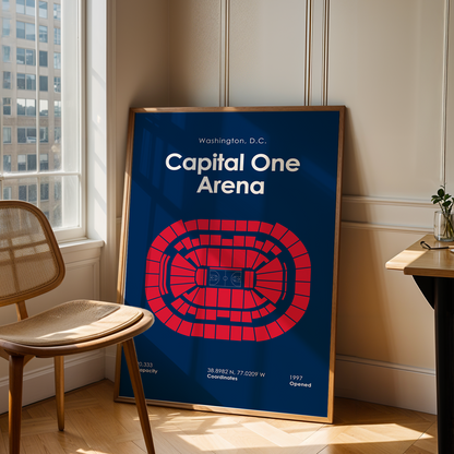 Framed poster of Capital One Arena in Washington, D.C. leaning against a wall in a room with a chair and table.