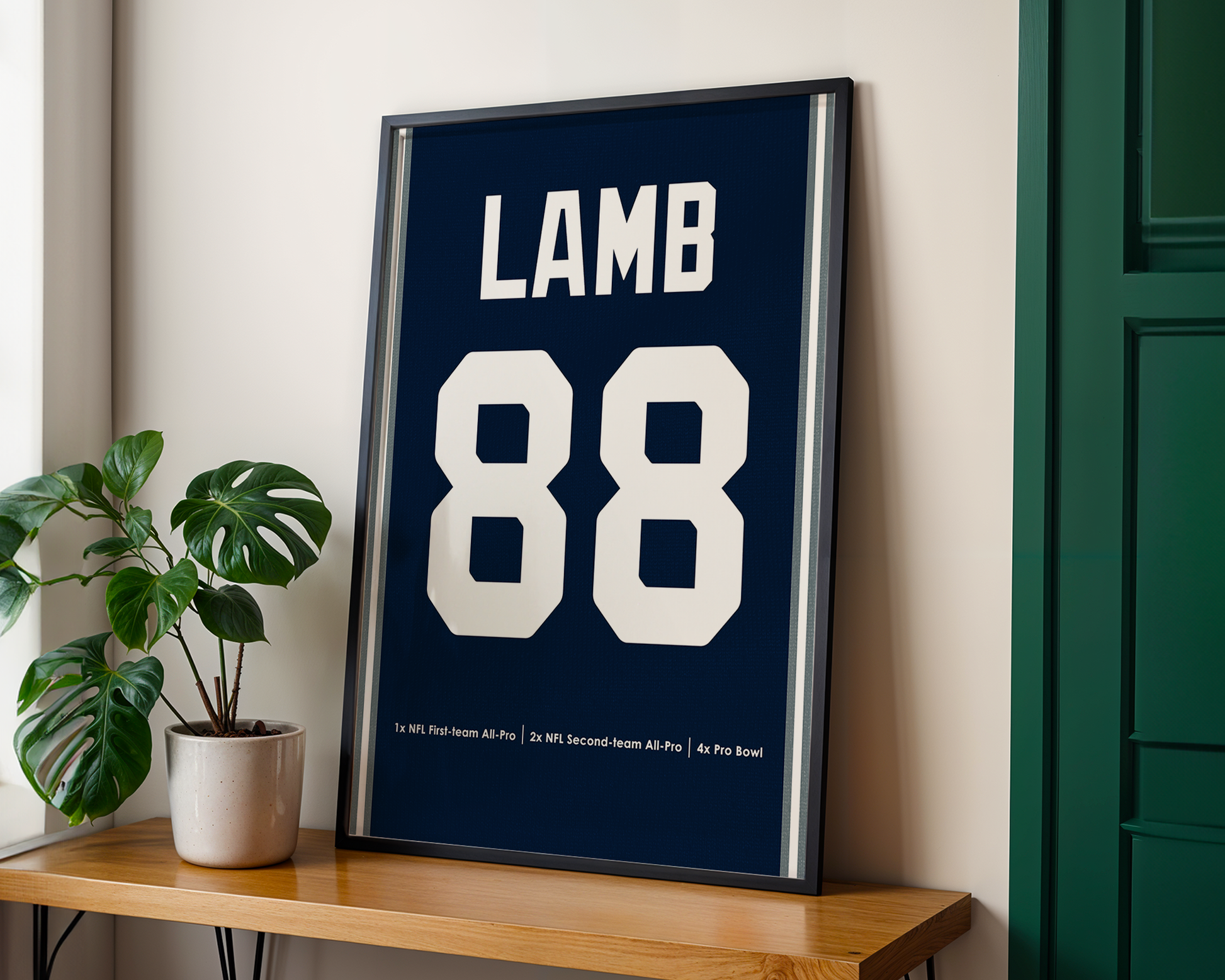 Framed poster with 'LAMB 88' on a wooden shelf next to a plant