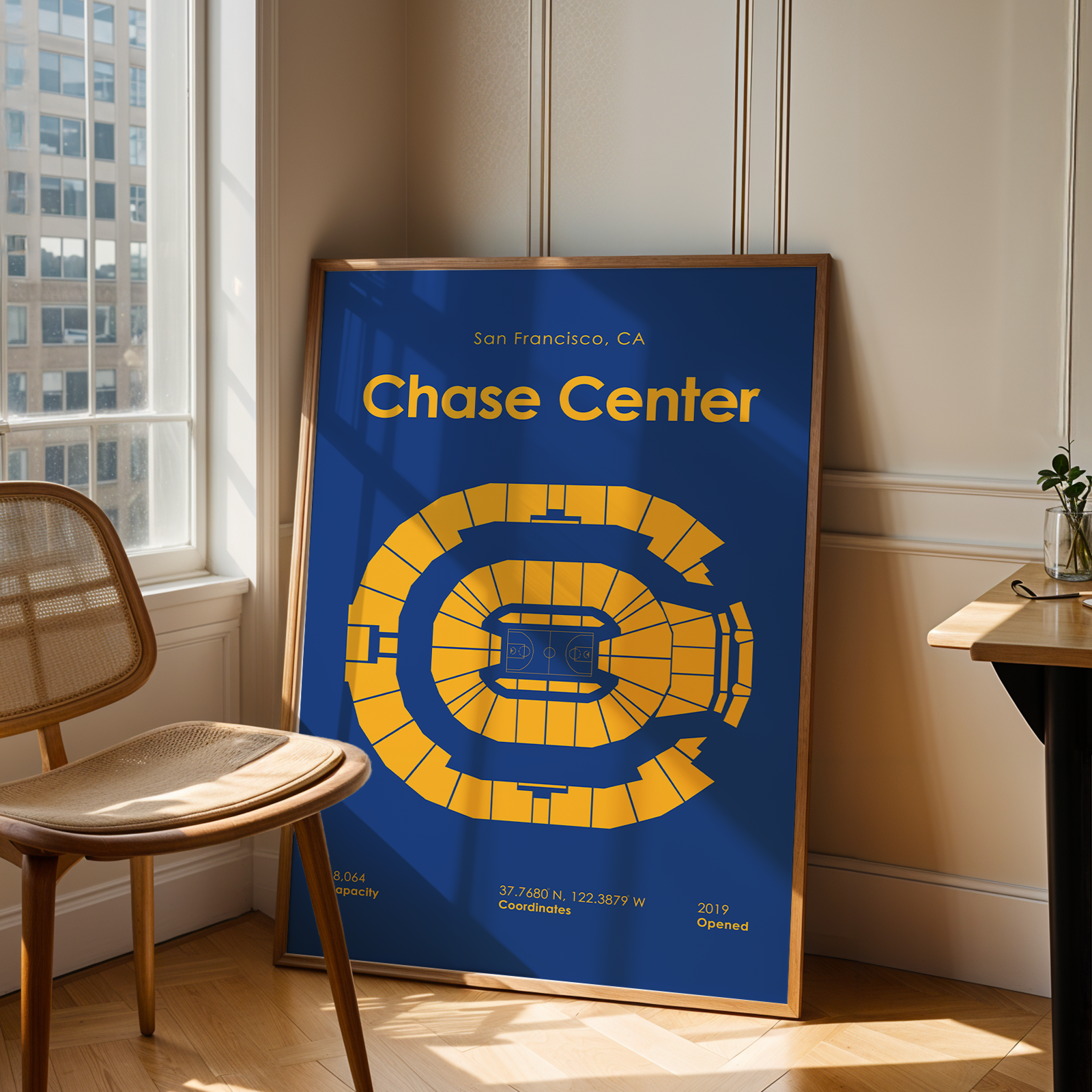 Poster of the Chase Center in San Francisco, CA, leaning against a wall in a room with a chair and table.