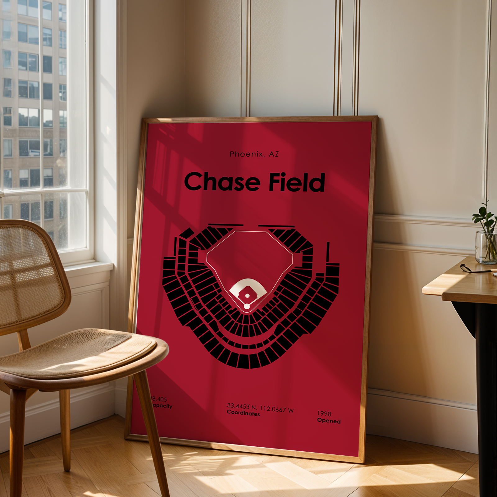 Framed poster of Chase Field in a room with a window and chair.
