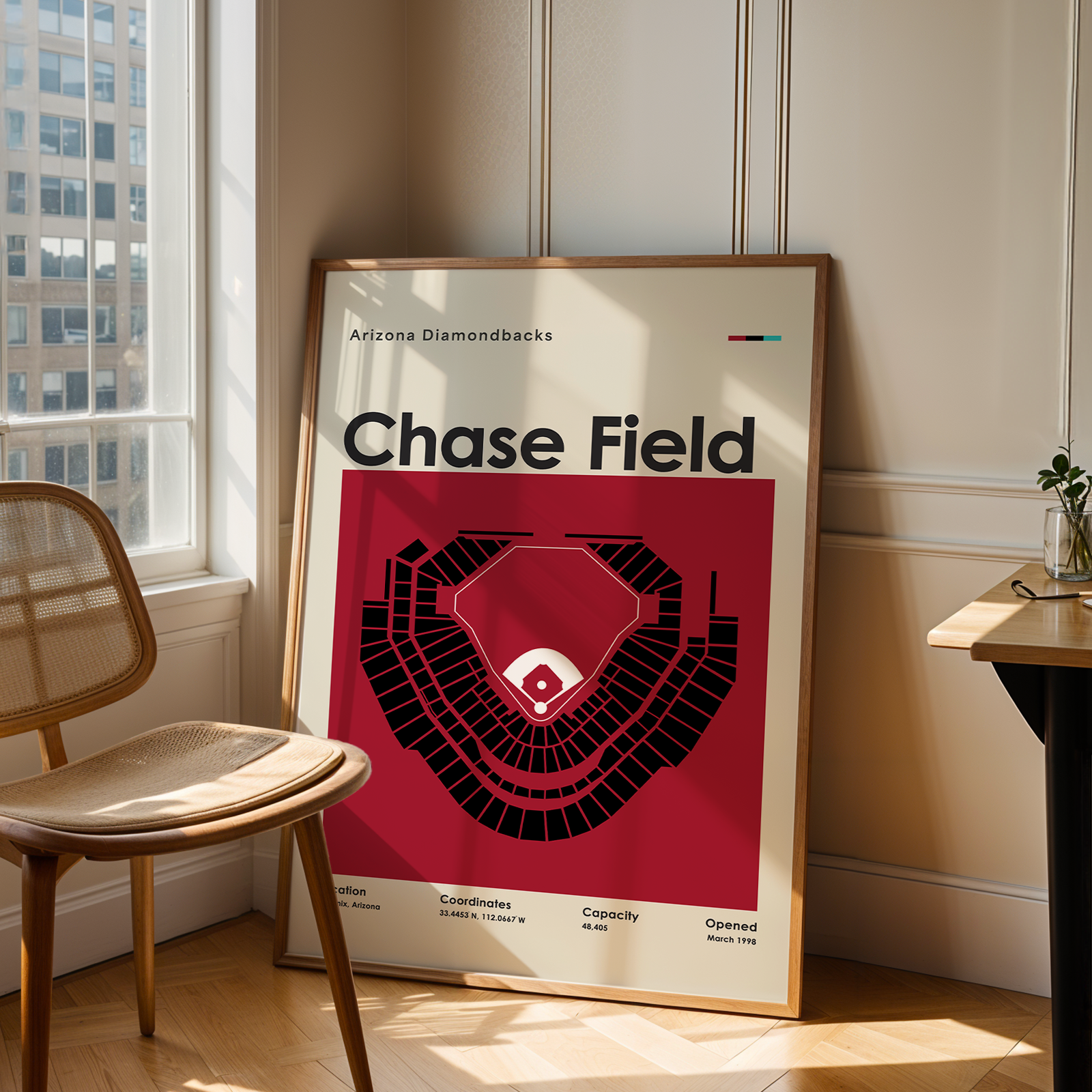 Framed poster of Chase Field in a room with a chair and table.