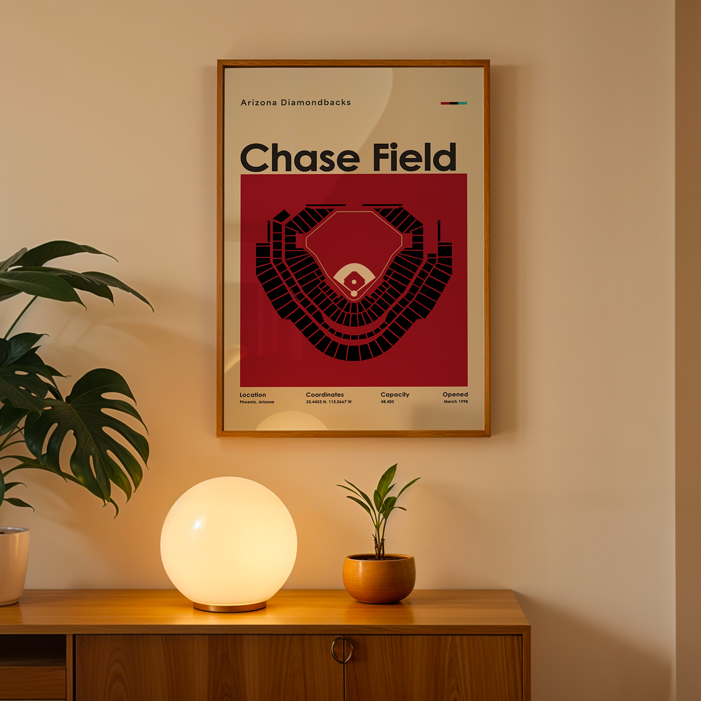 Framed poster of Chase Field on a wall above a wooden cabinet with decorative items.