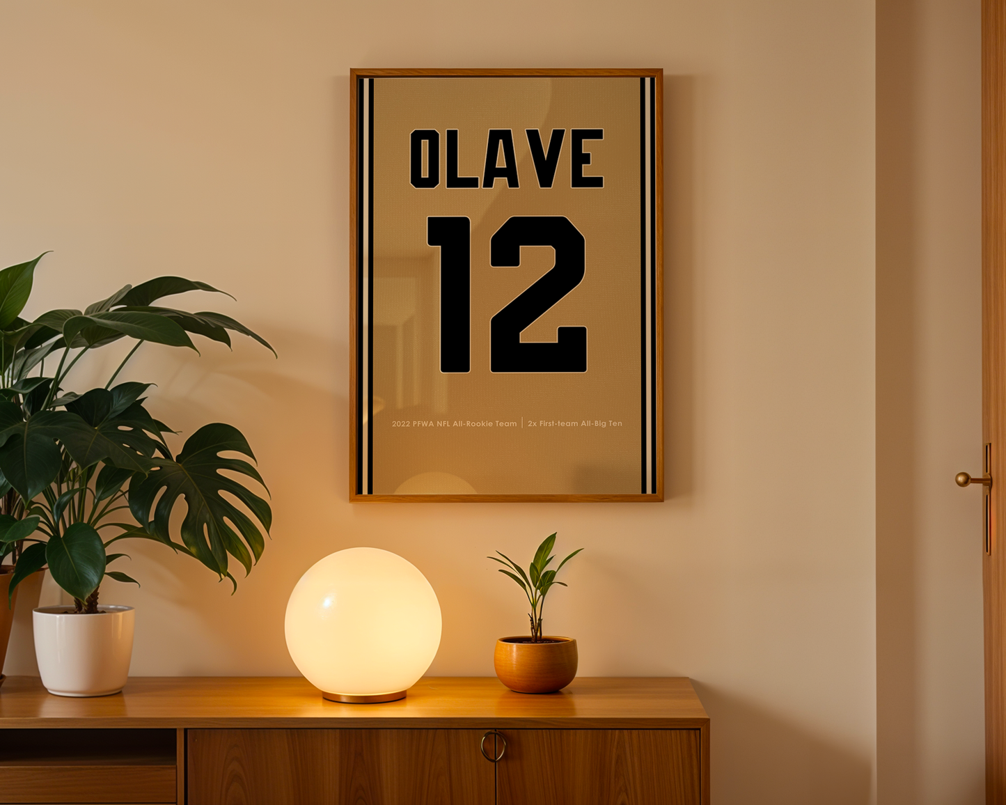 Framed artwork with 'OLAVE 12' on a wall above a wooden cabinet with decorative items.