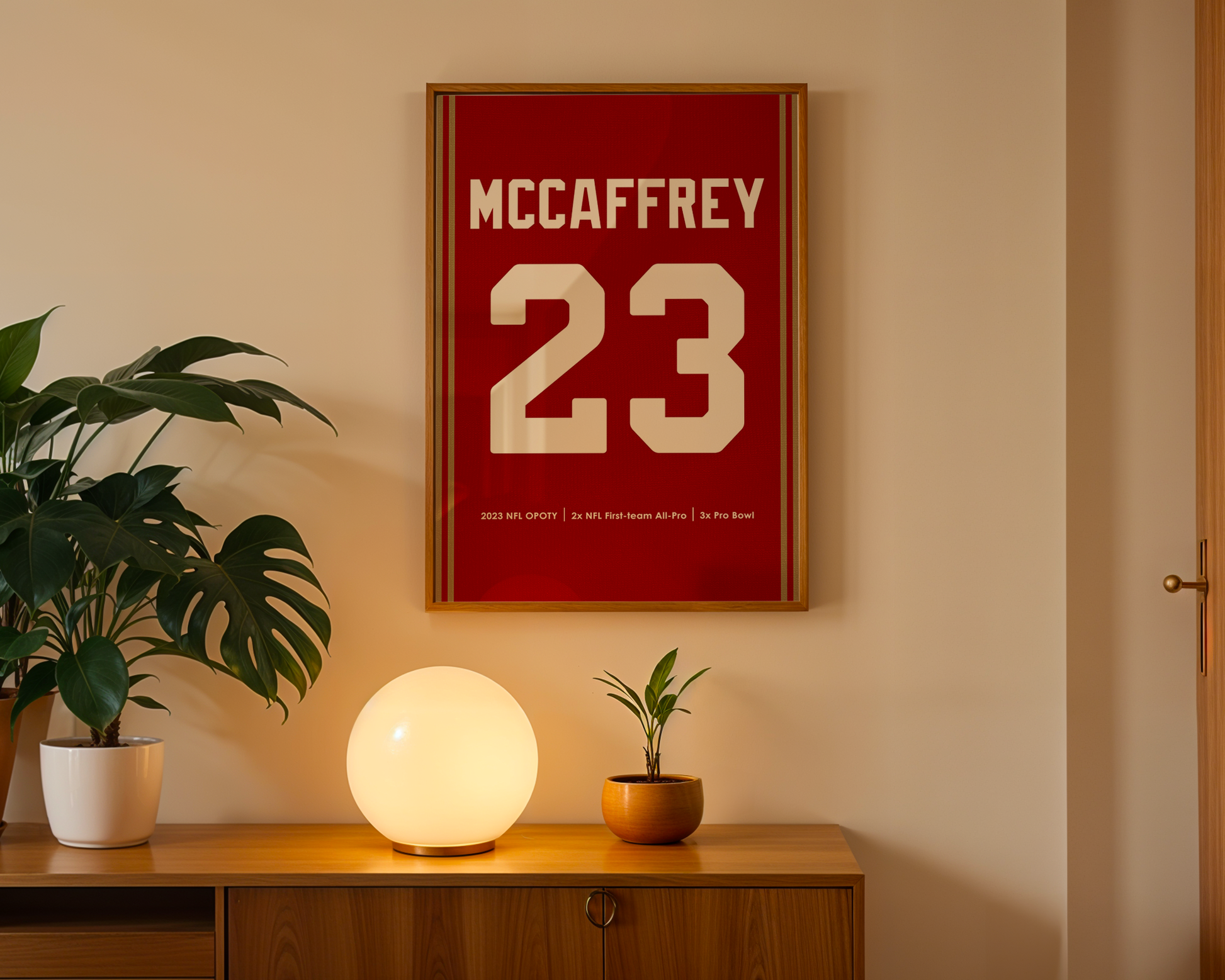 Framed sports jersey with 'McCaffrey 23' on a wall above a wooden cabinet with decorative items.