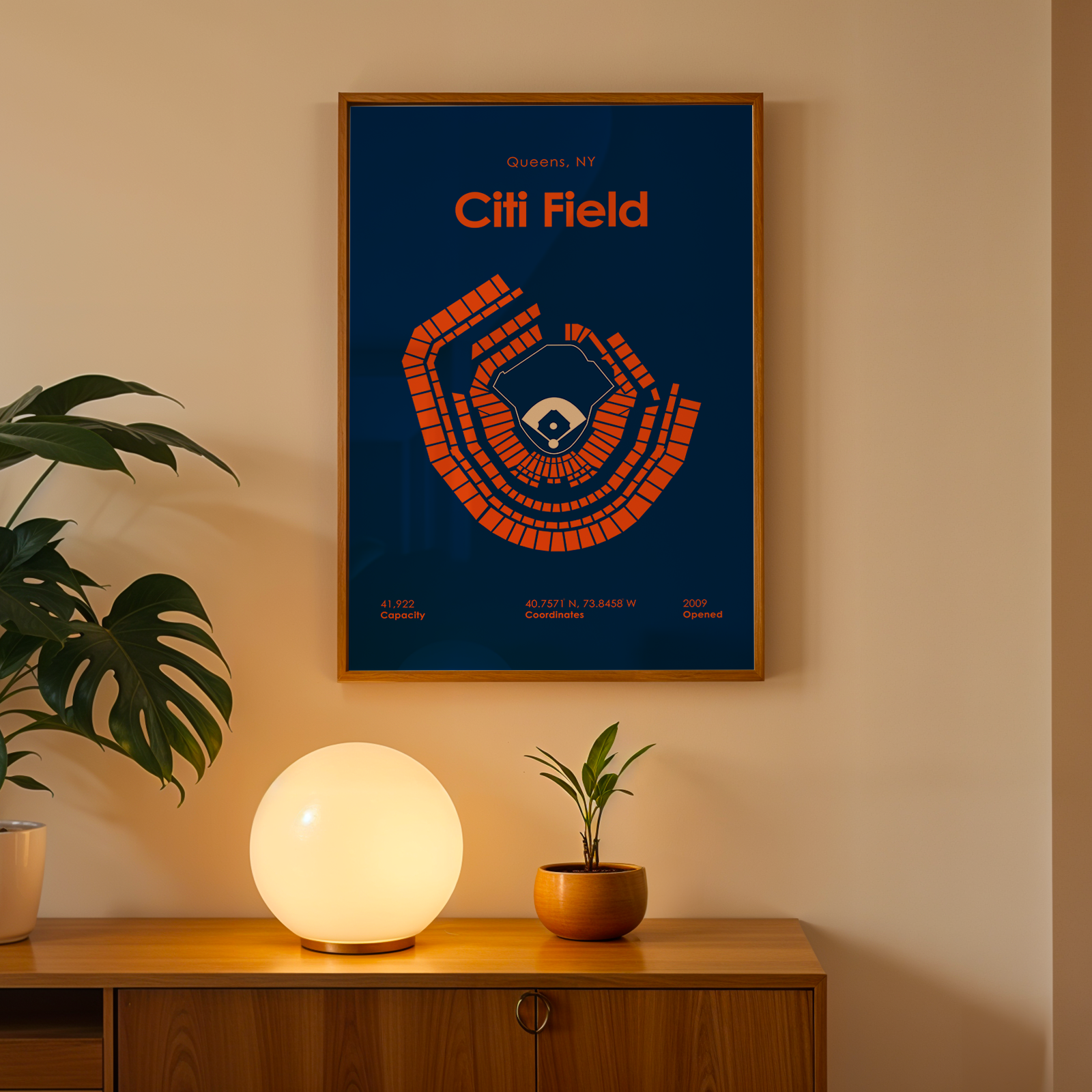 Framed poster of Citi Field on a wall above a wooden cabinet with decorative items.