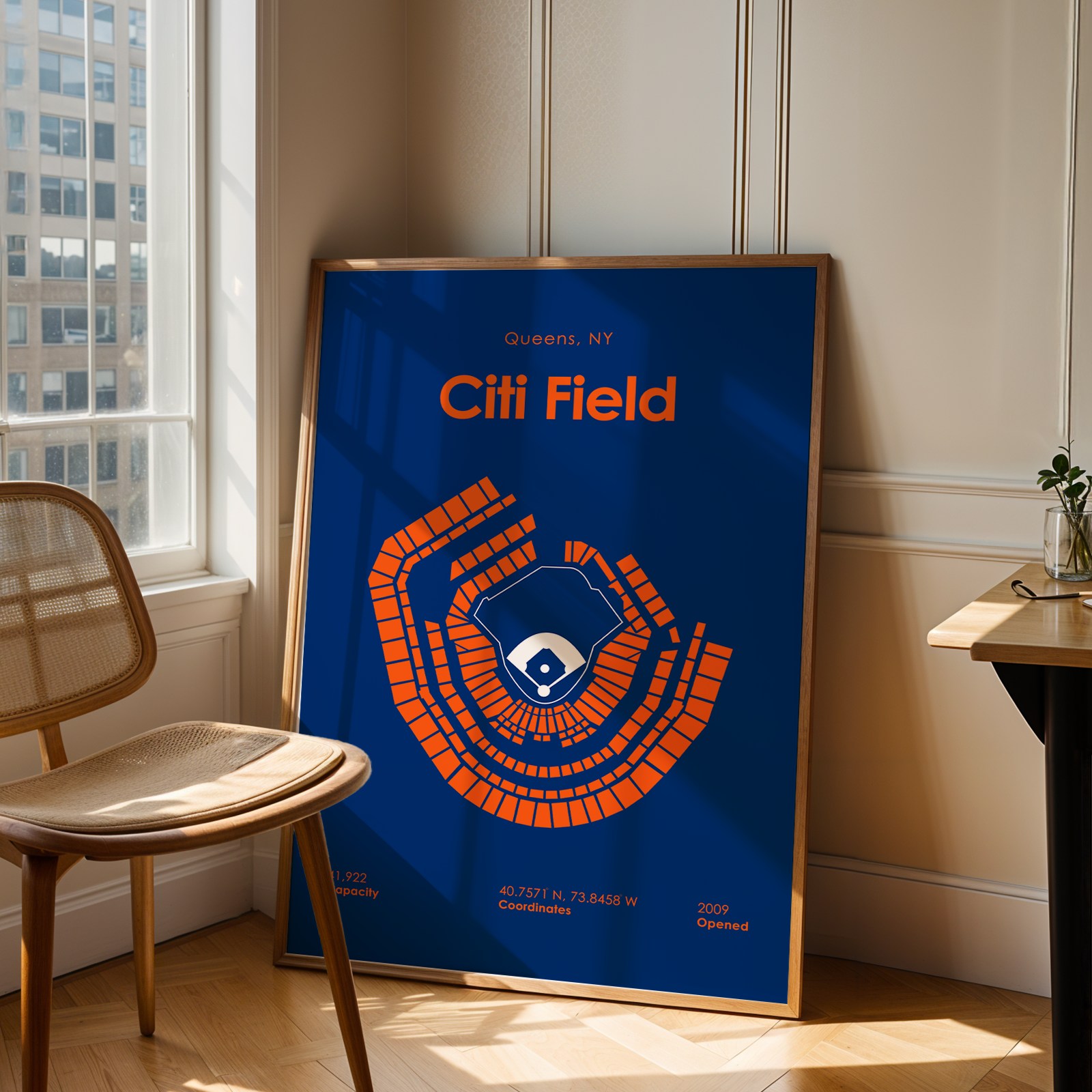 Framed poster of Citi Field in a room with a chair and table.