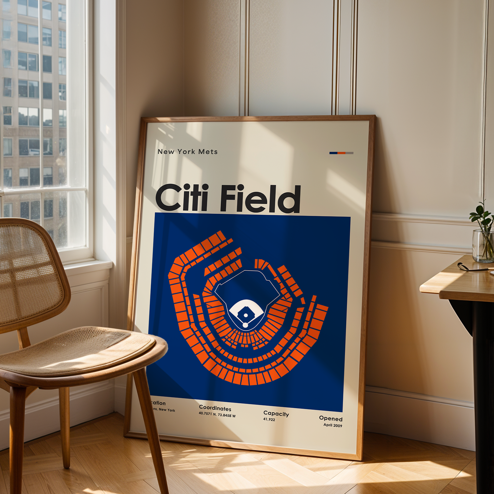 Framed poster of Citi Field in a room with a chair and table.