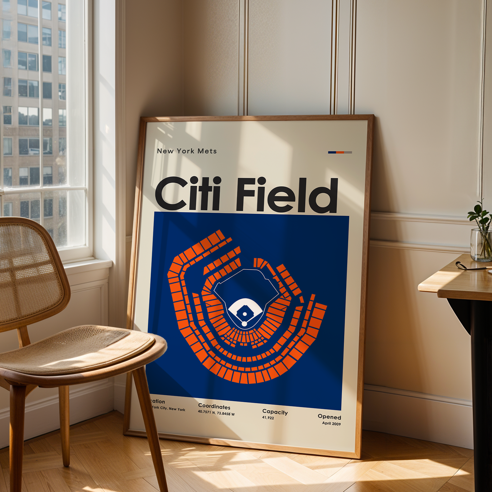 Framed poster of Citi Field in a room with a chair and table.