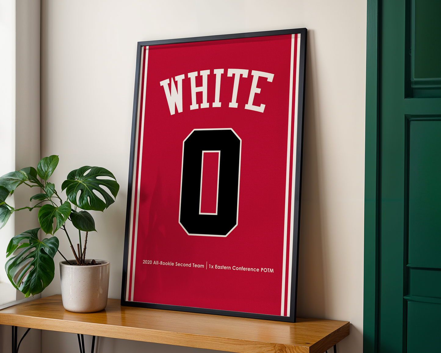 Framed red jersey with 'WHITE' and number '0' on a wooden shelf.