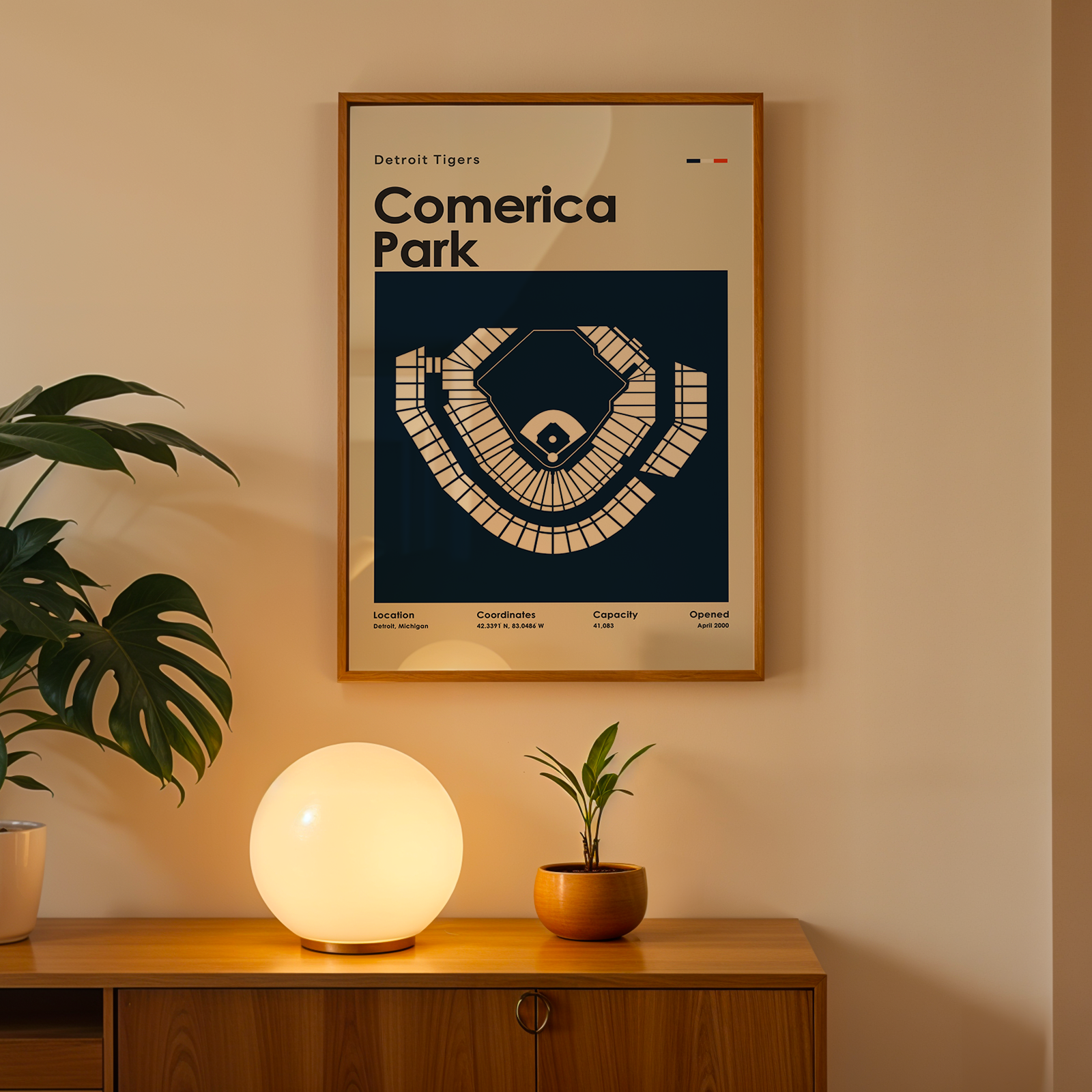 Framed poster of Comerica Park on a wall above a wooden cabinet with decorative items.
