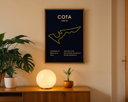Framed poster with 'COTA' design on a wall above a wooden cabinet with decorative items.