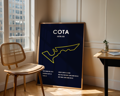 Framed poster with 'COTA' and map design in a room with a chair and window.