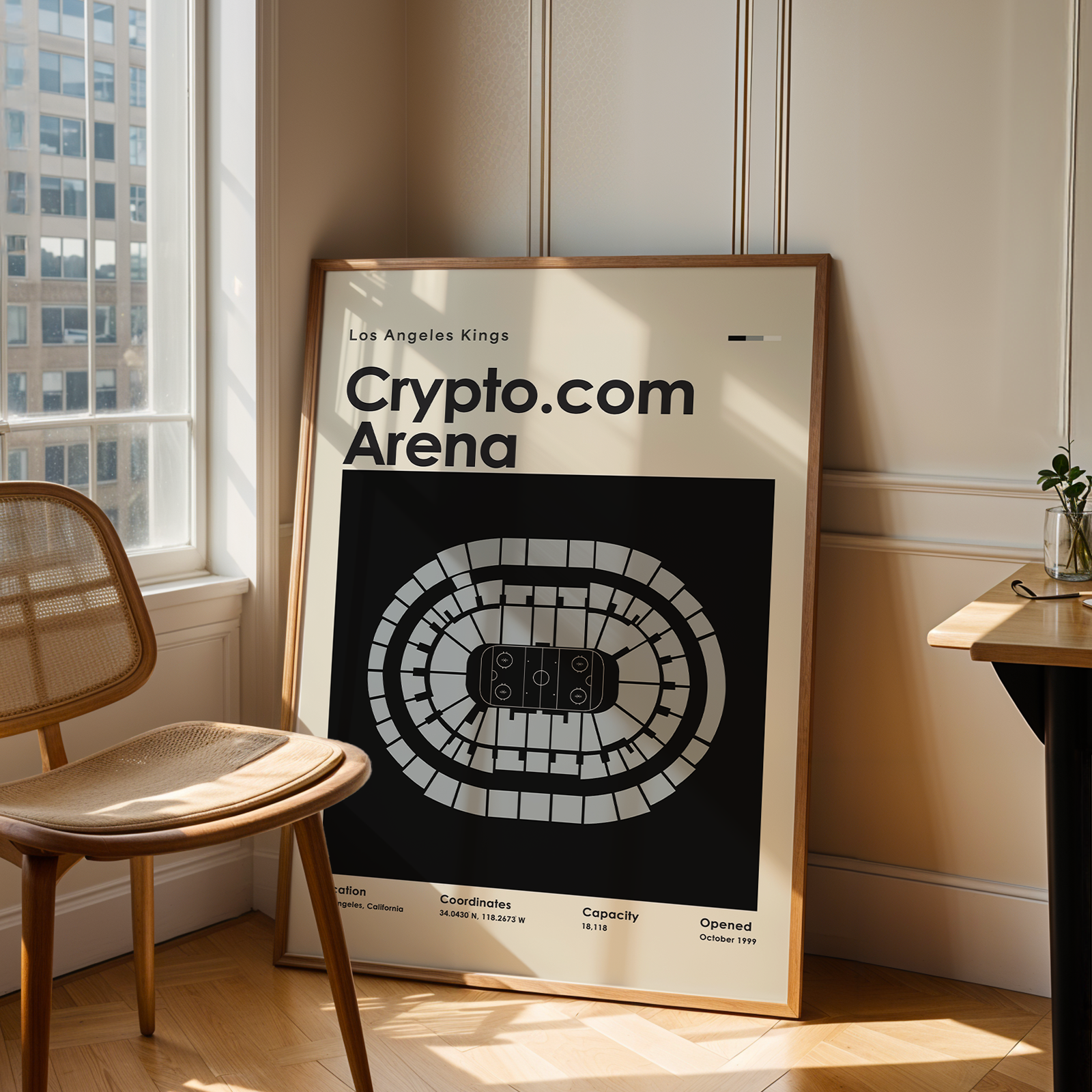 Framed poster of Crypto.com Arena in a room with a chair and table.