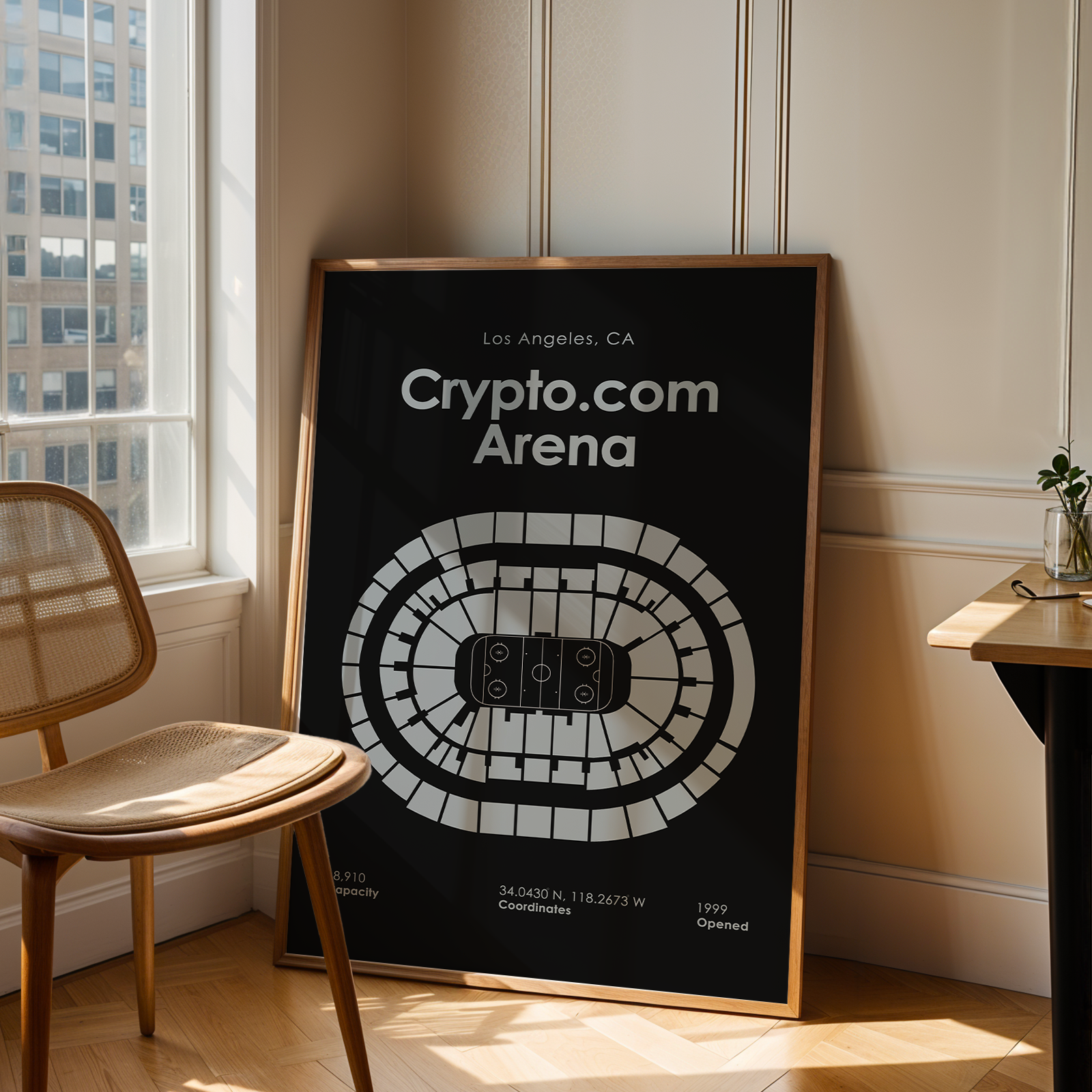 Framed poster of Crypto.com Arena in a room with a chair and window.