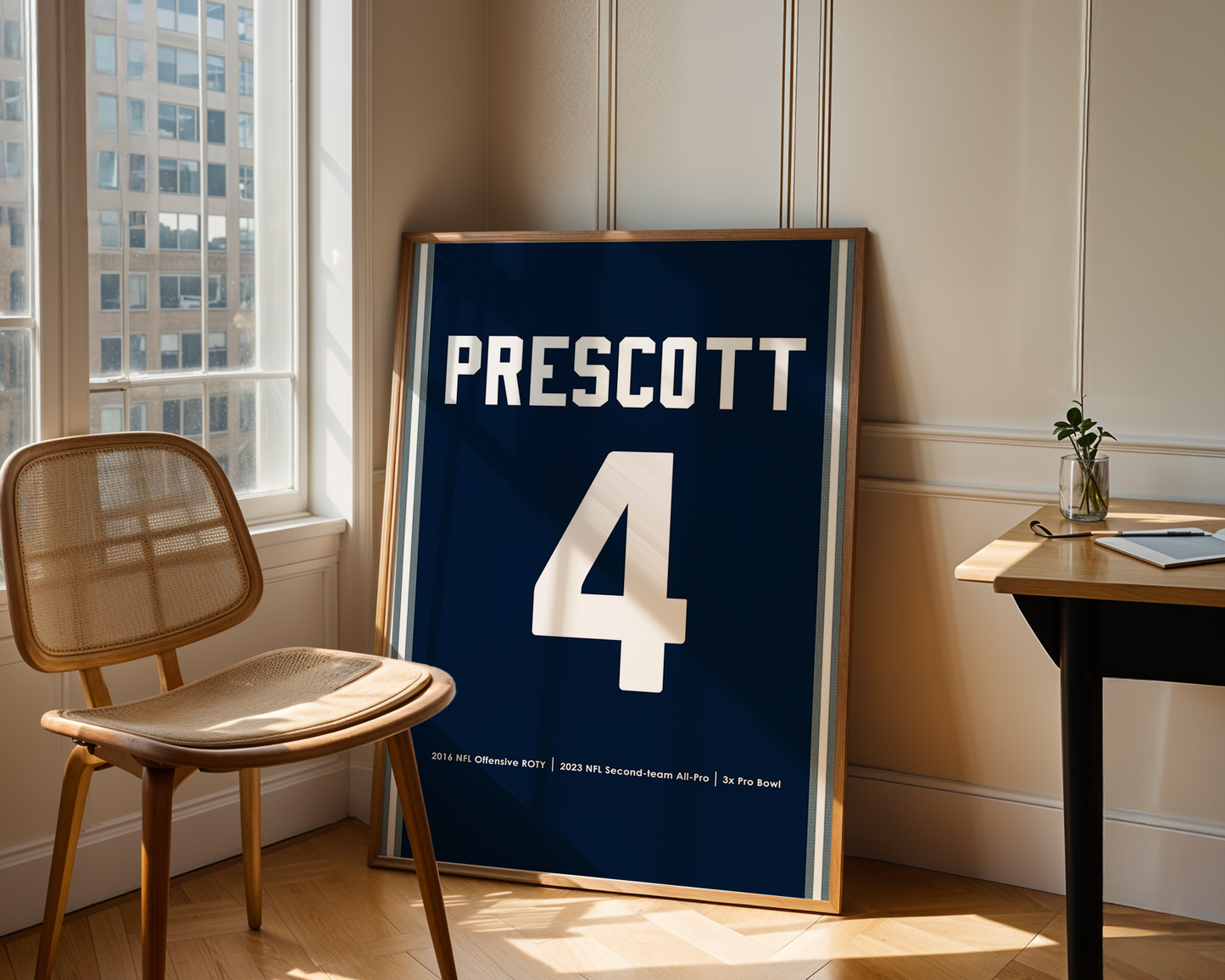 Framed sports jersey with 'Prescott' and number '4' in a room with a window and chair.
