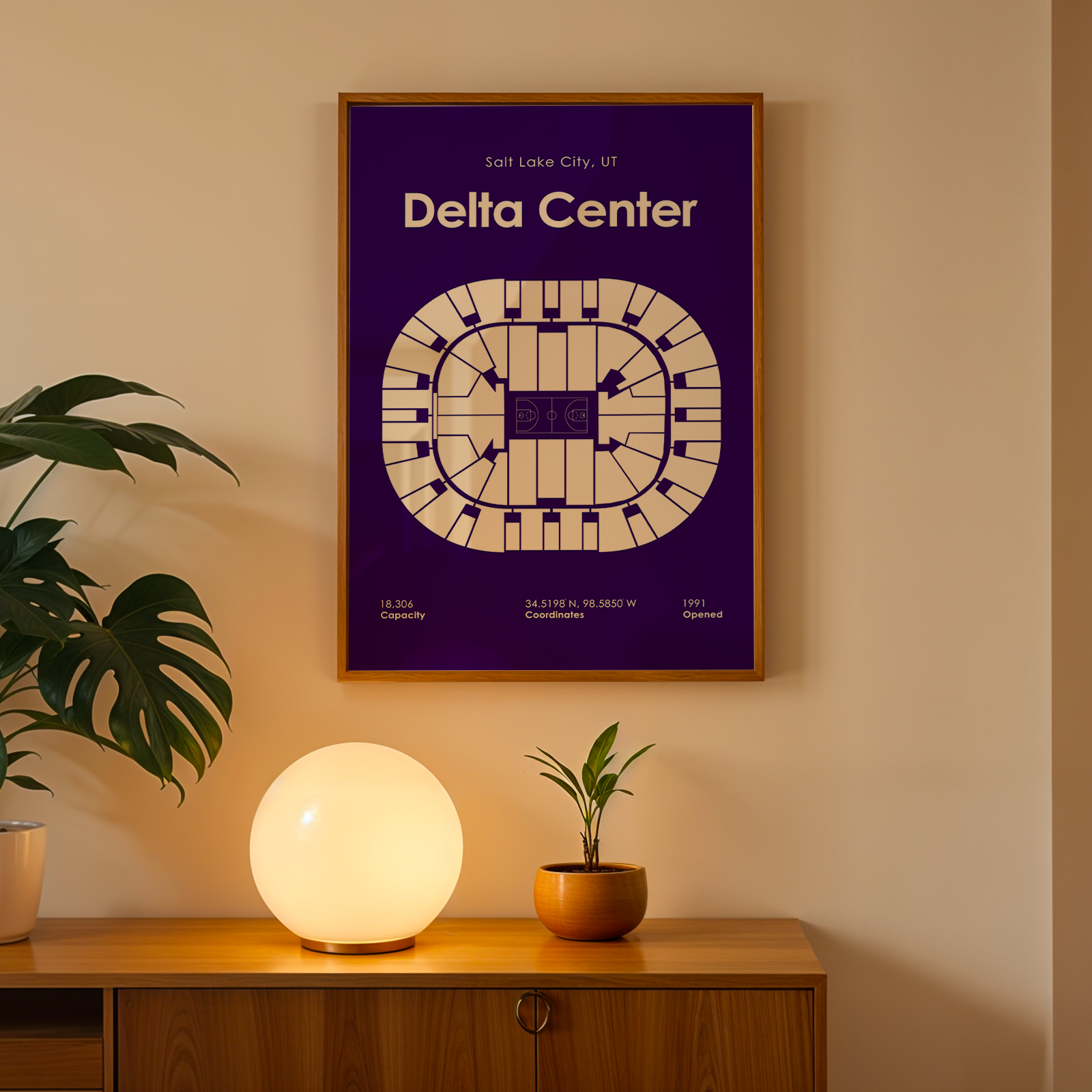 Framed poster of Delta Center on a wall above a wooden cabinet with decorative items.