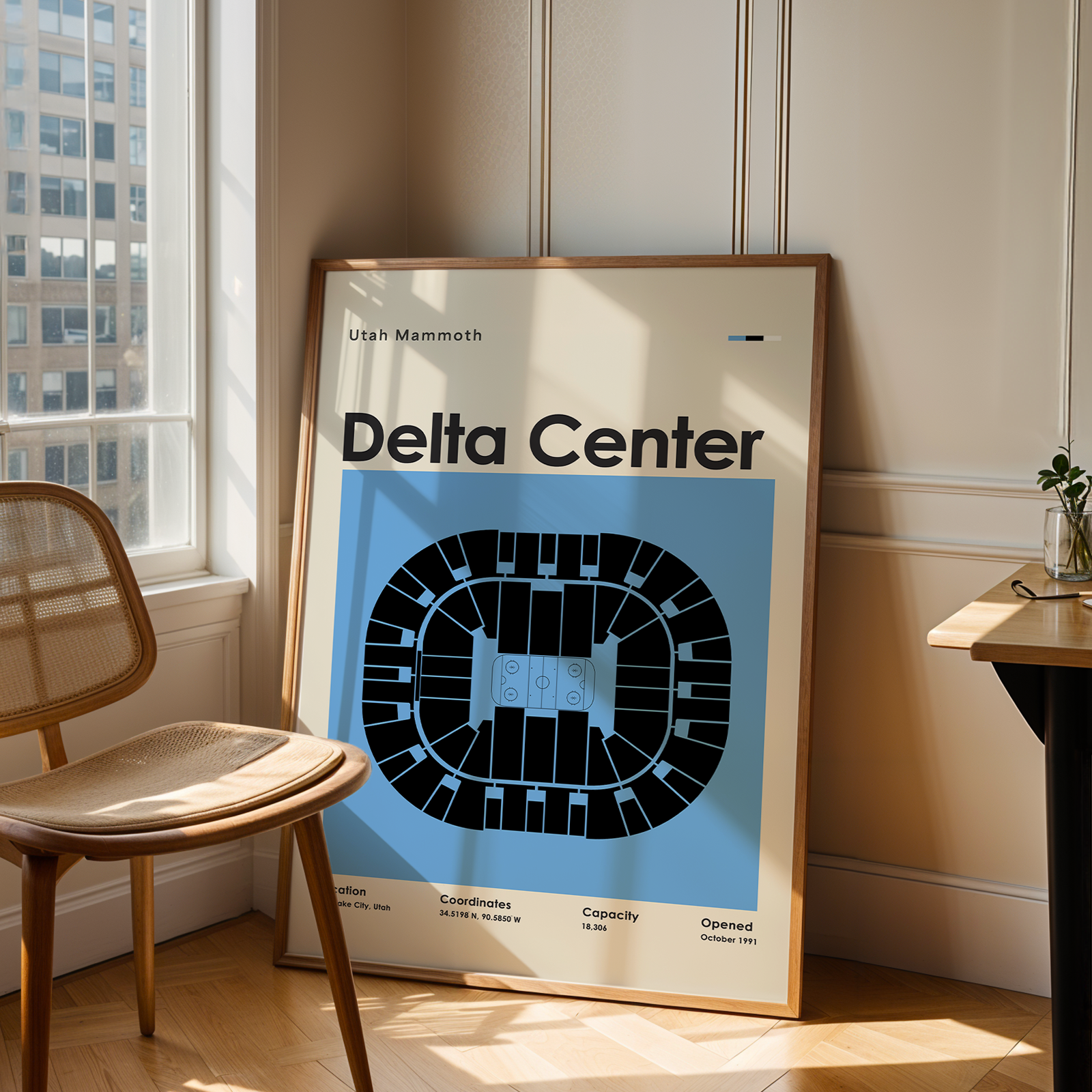 Framed poster of Delta Center in a room with a chair and table.