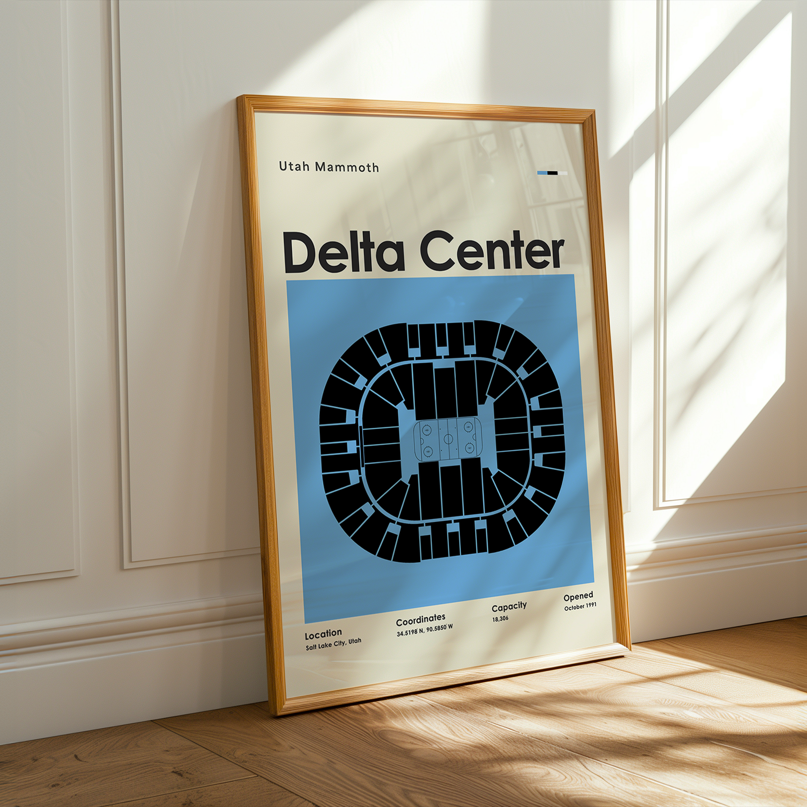 Framed poster of Delta Center layout on a wooden floor with sunlight streaming through a window.