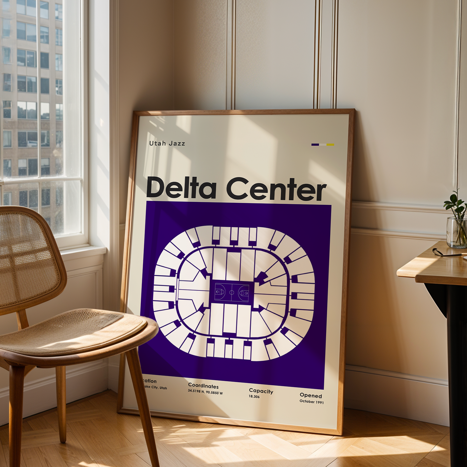 Framed poster of Delta Center in a room with a chair and table.