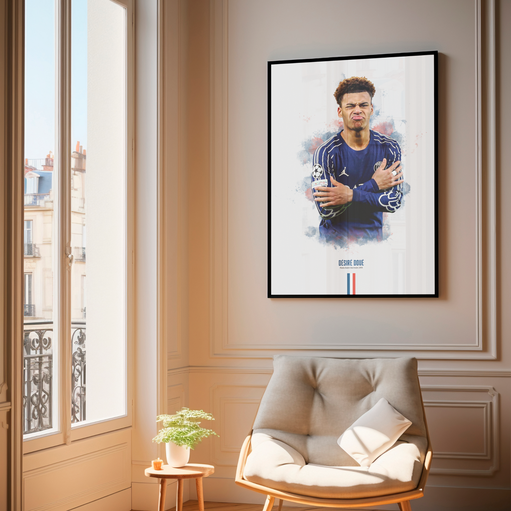 Framed poster print of soccer player Desire Doue, wearing a PSG jersey, on a wall above a chair.