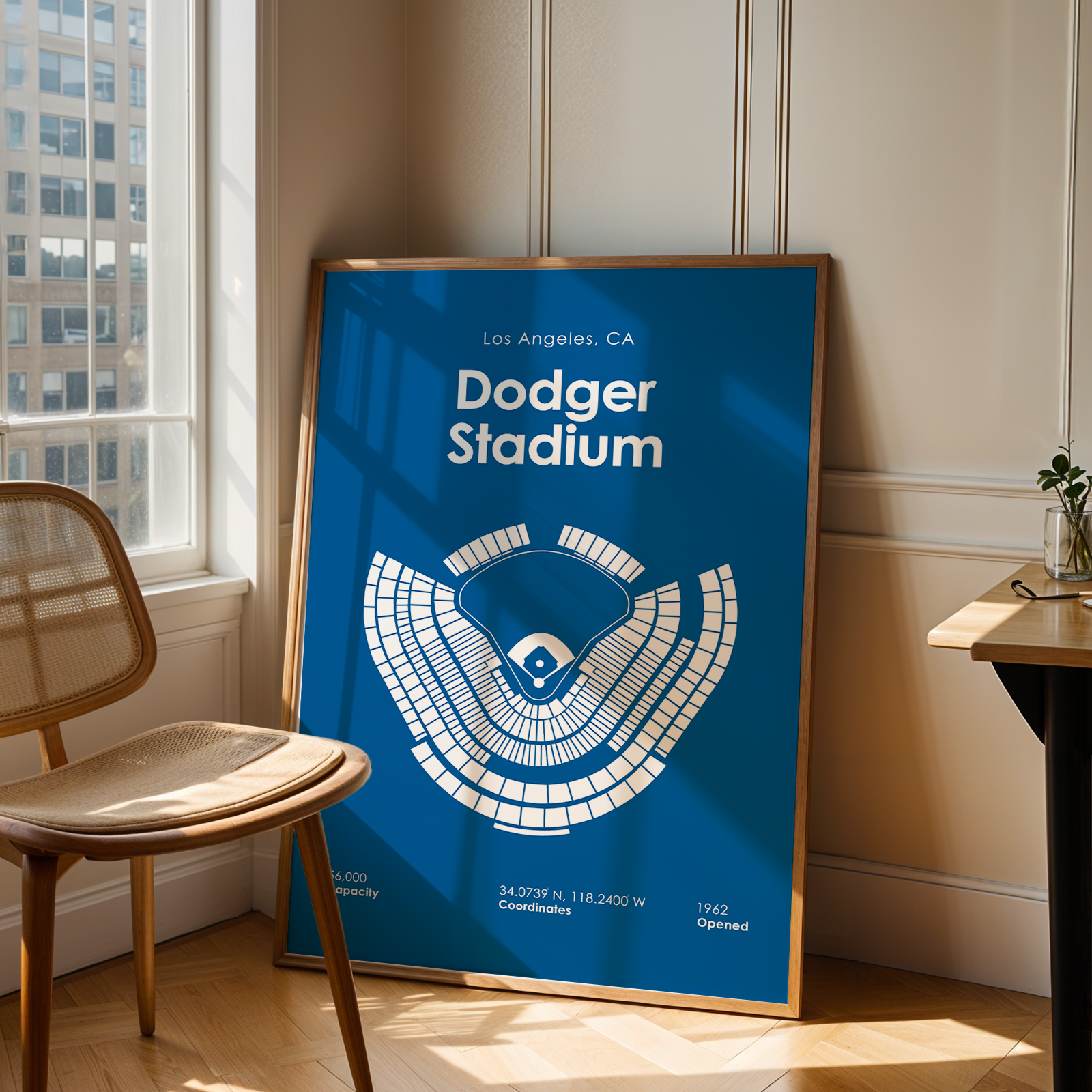 Framed poster of Dodger Stadium in a room with a chair and window.