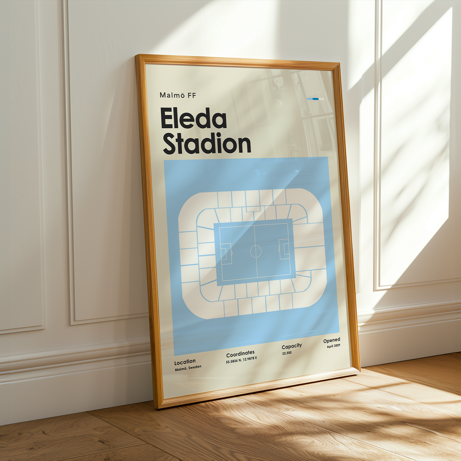 Framed poster of Eleda Stadion with architectural design on a wall.