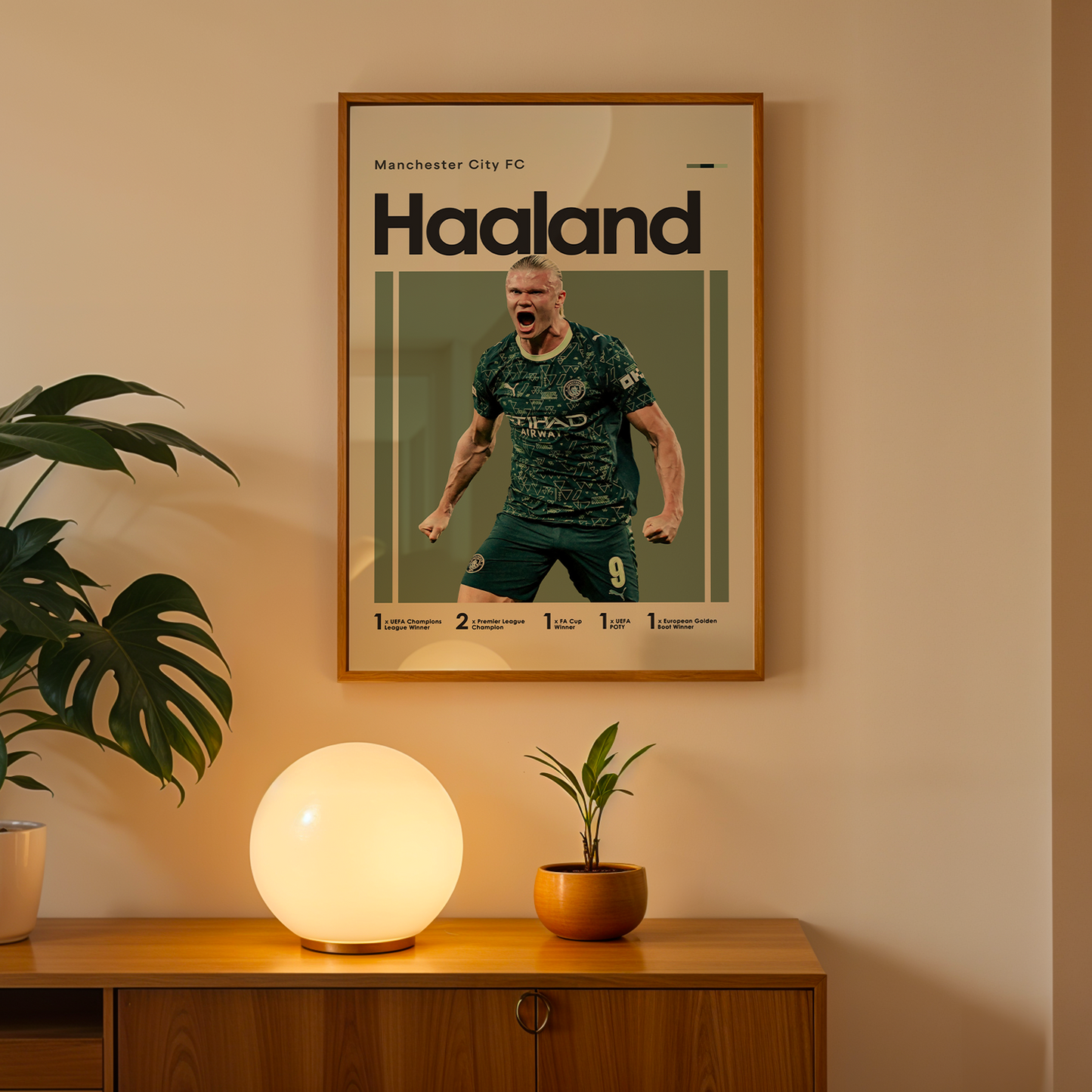 Framed poster of a soccer player with 'Haaland' on a wall above a wooden cabinet with decorative items.