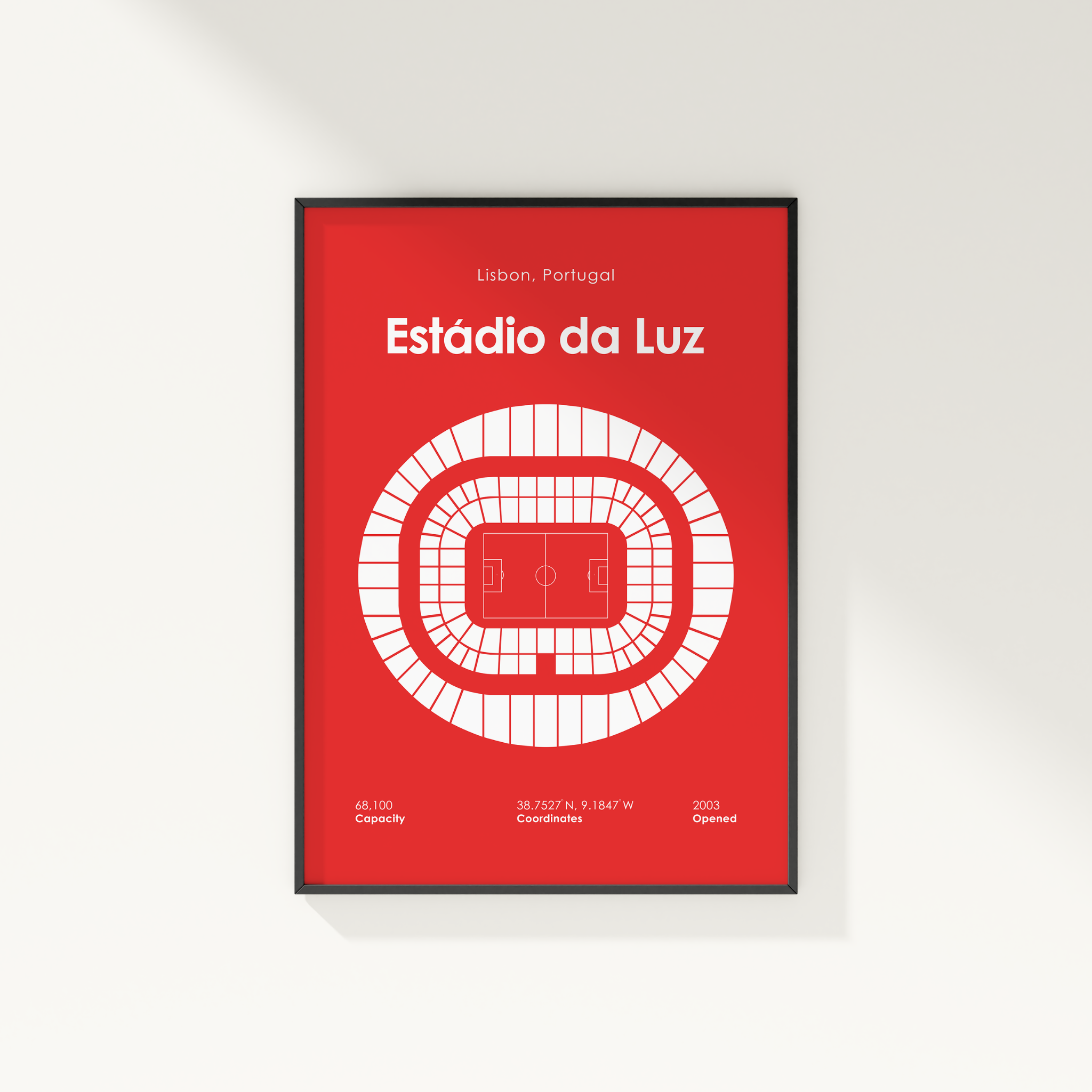 A framed minimalist sports poster of Estãdio da Luz in Lisbon, Portugal, featuring a white stadium layout on a solid red background, mounted on a light gray wall.