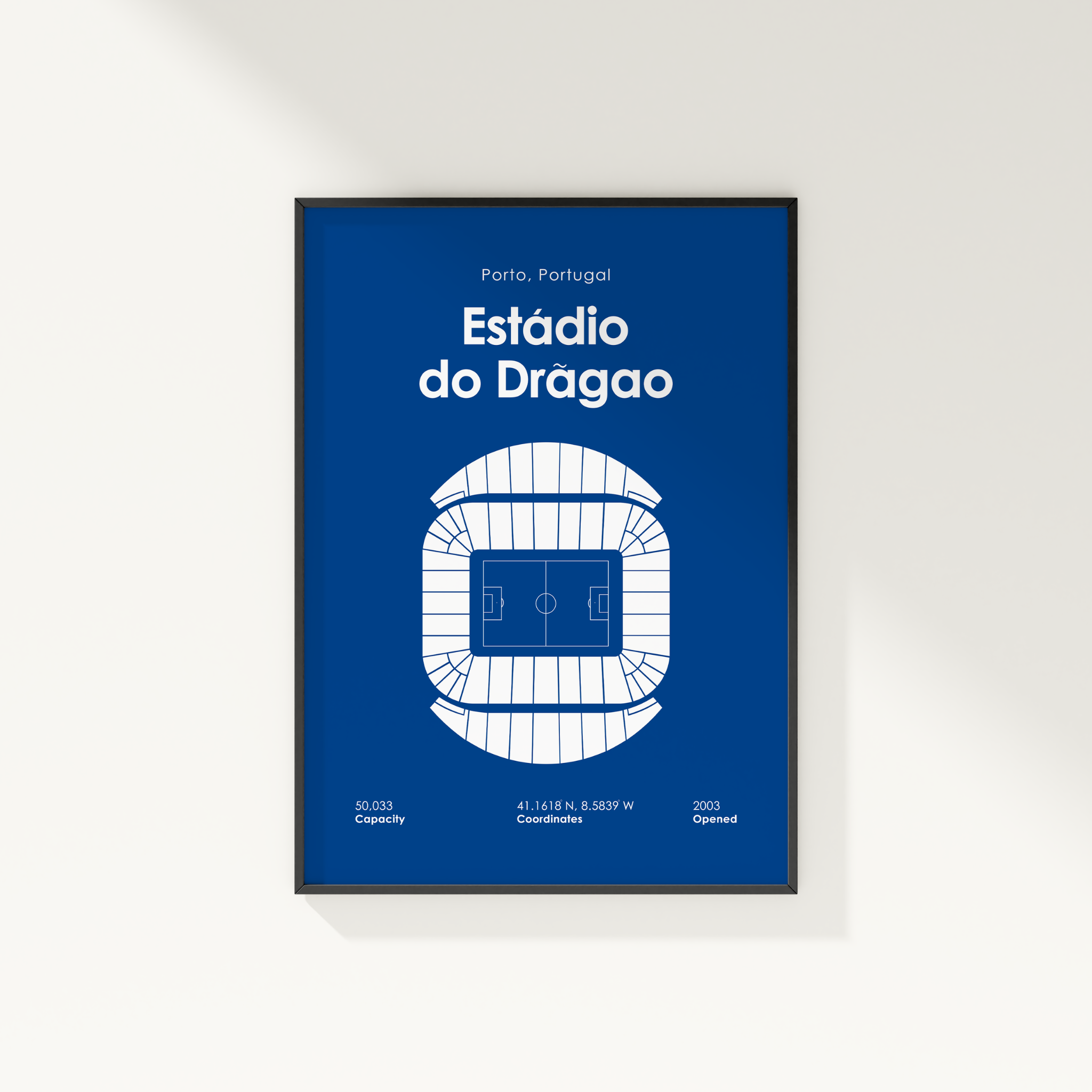 A framed poster featuring a blue and white architectural-style illustration of the Estádio do Drágao stadium in Porto, Portugal, mounted on a light beige wall.