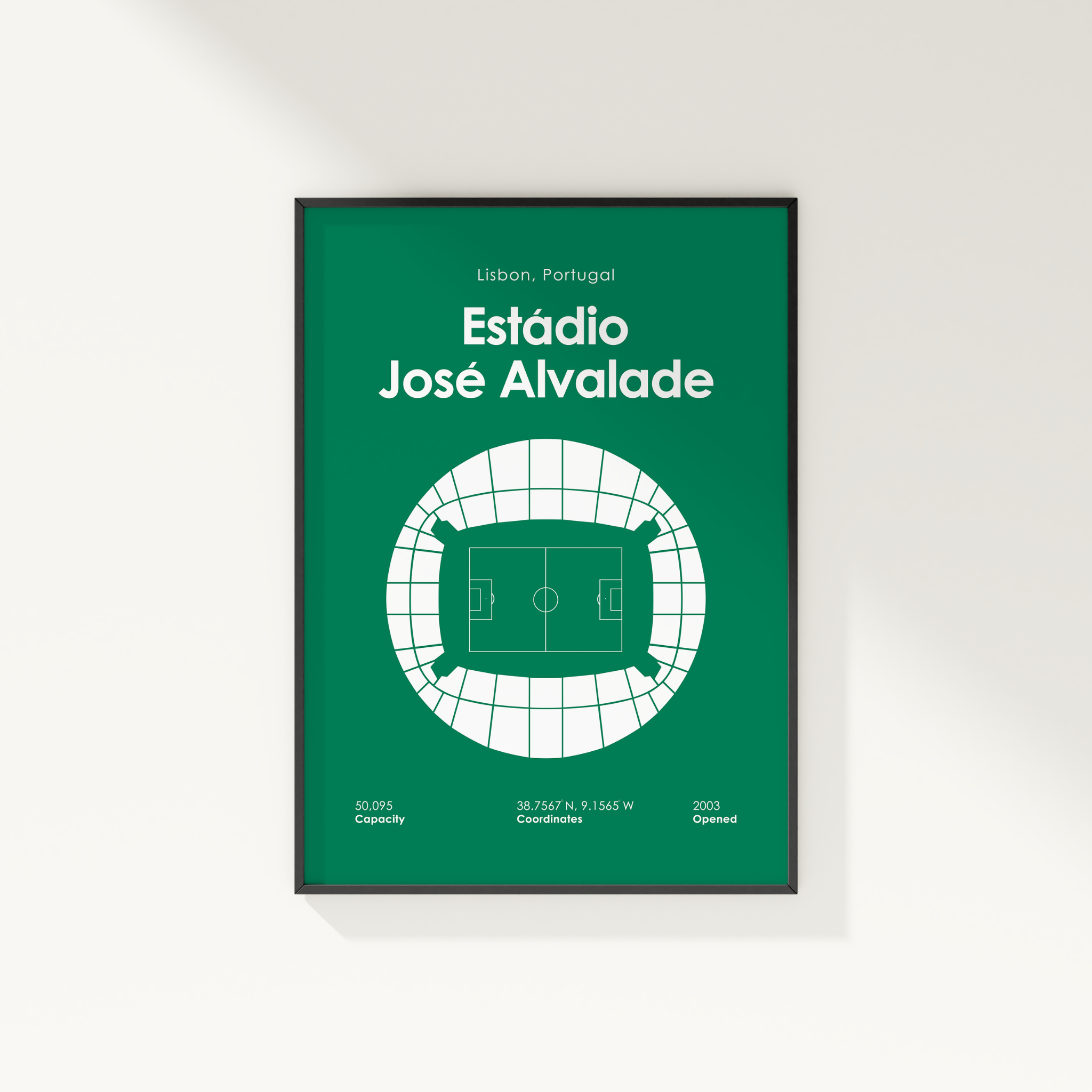 A framed green sports poster of Estádio José Alvalade in Lisbon, Portugal, featuring a white stadium floor plan and text details, shown hanging on a light gray wall.