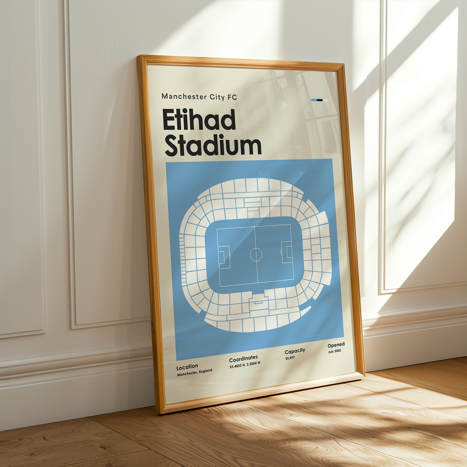 Framed poster of Manchester City FC Etihad Stadium layout on a wall.