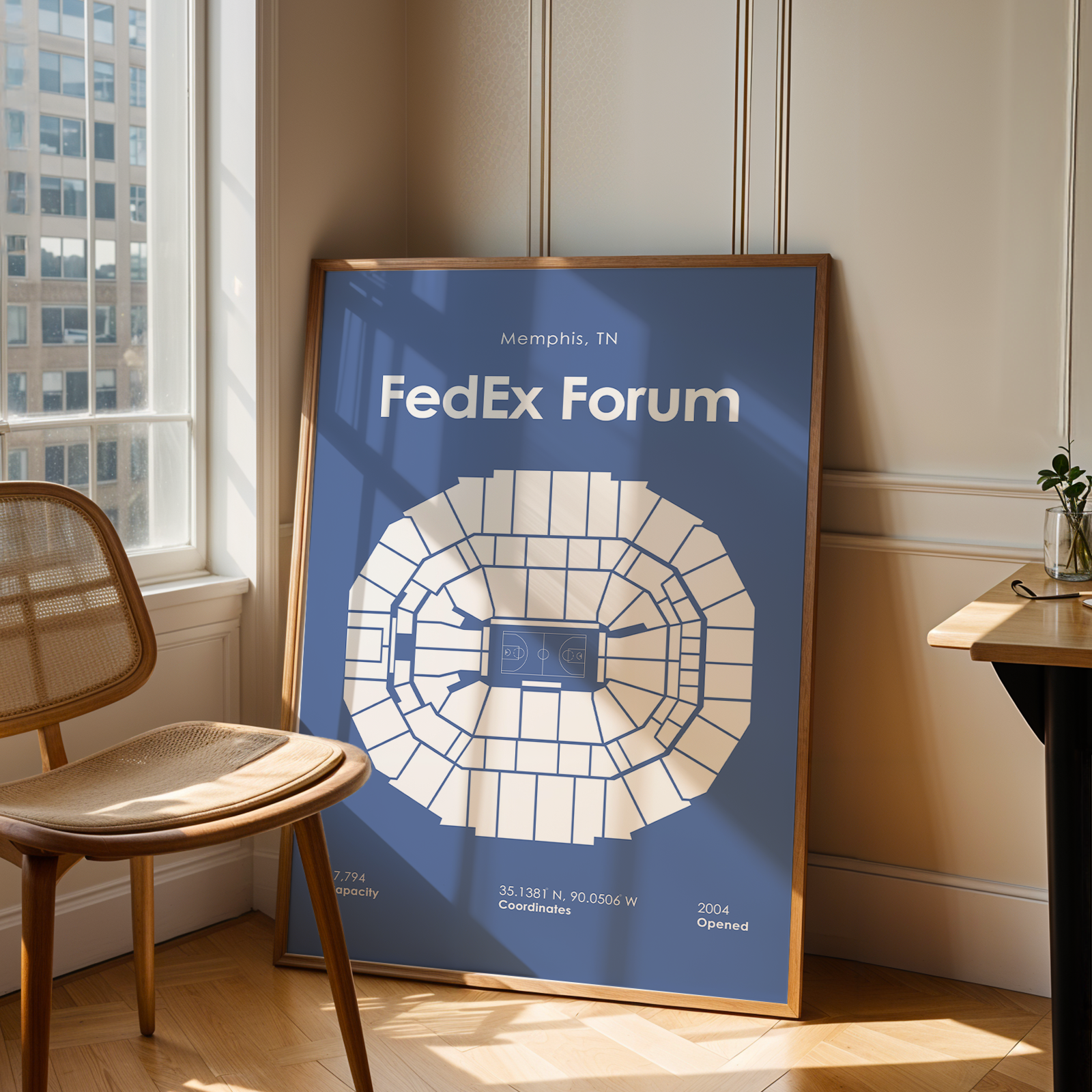 Framed poster of FedEx Forum in a room with a chair and table.