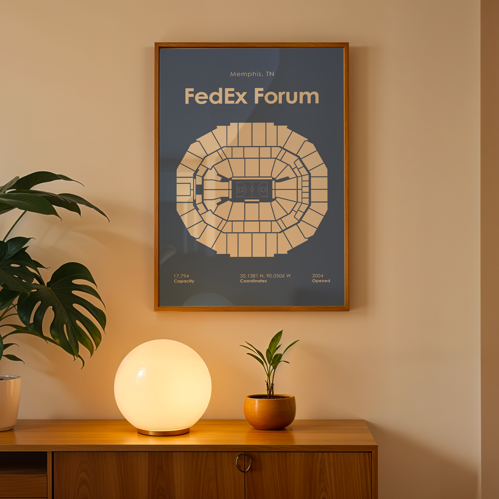 Framed map of FedEx Forum on a wall above a wooden cabinet with decorative items.
