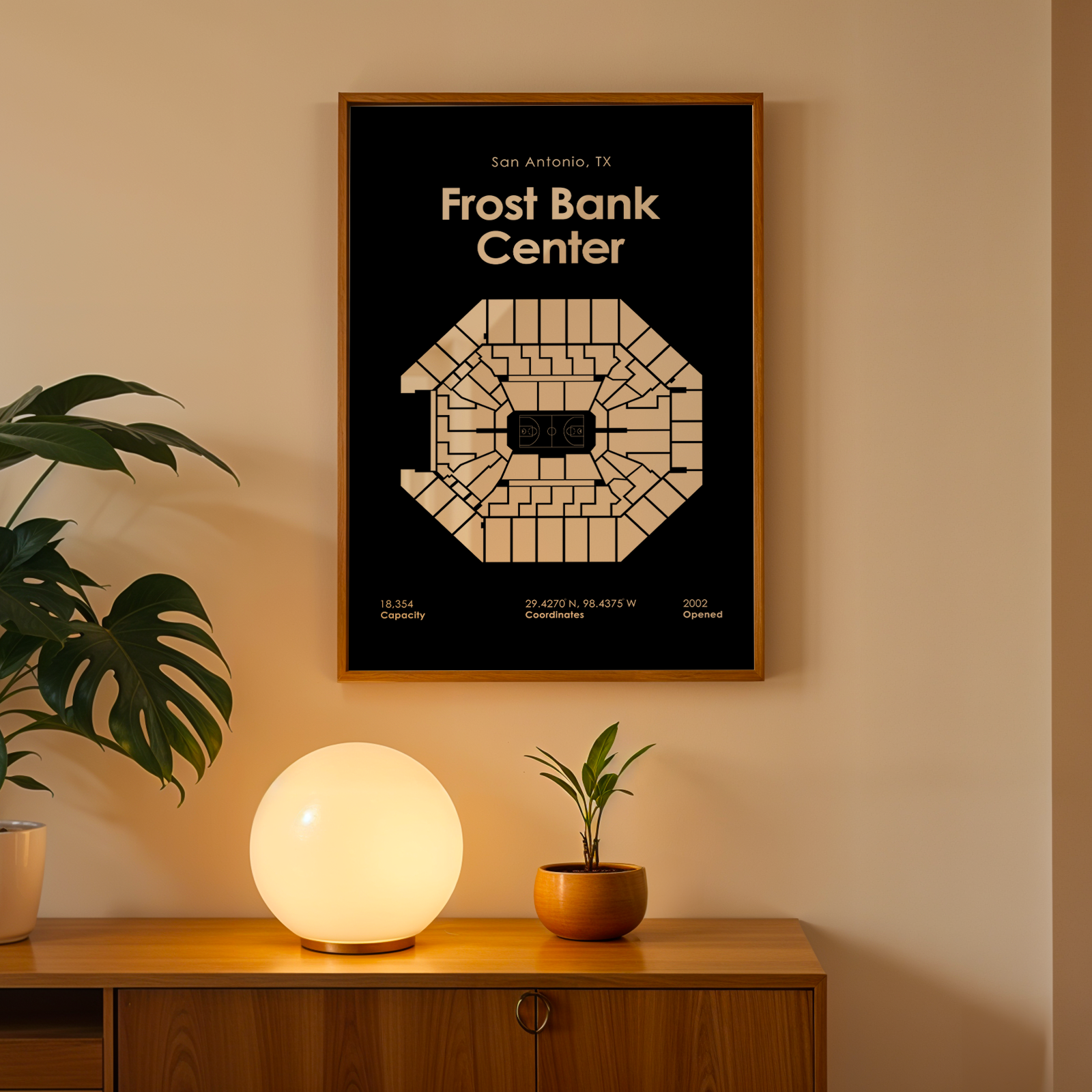 Framed poster of Frost Bank Center on a wall above a wooden cabinet with decorative items.