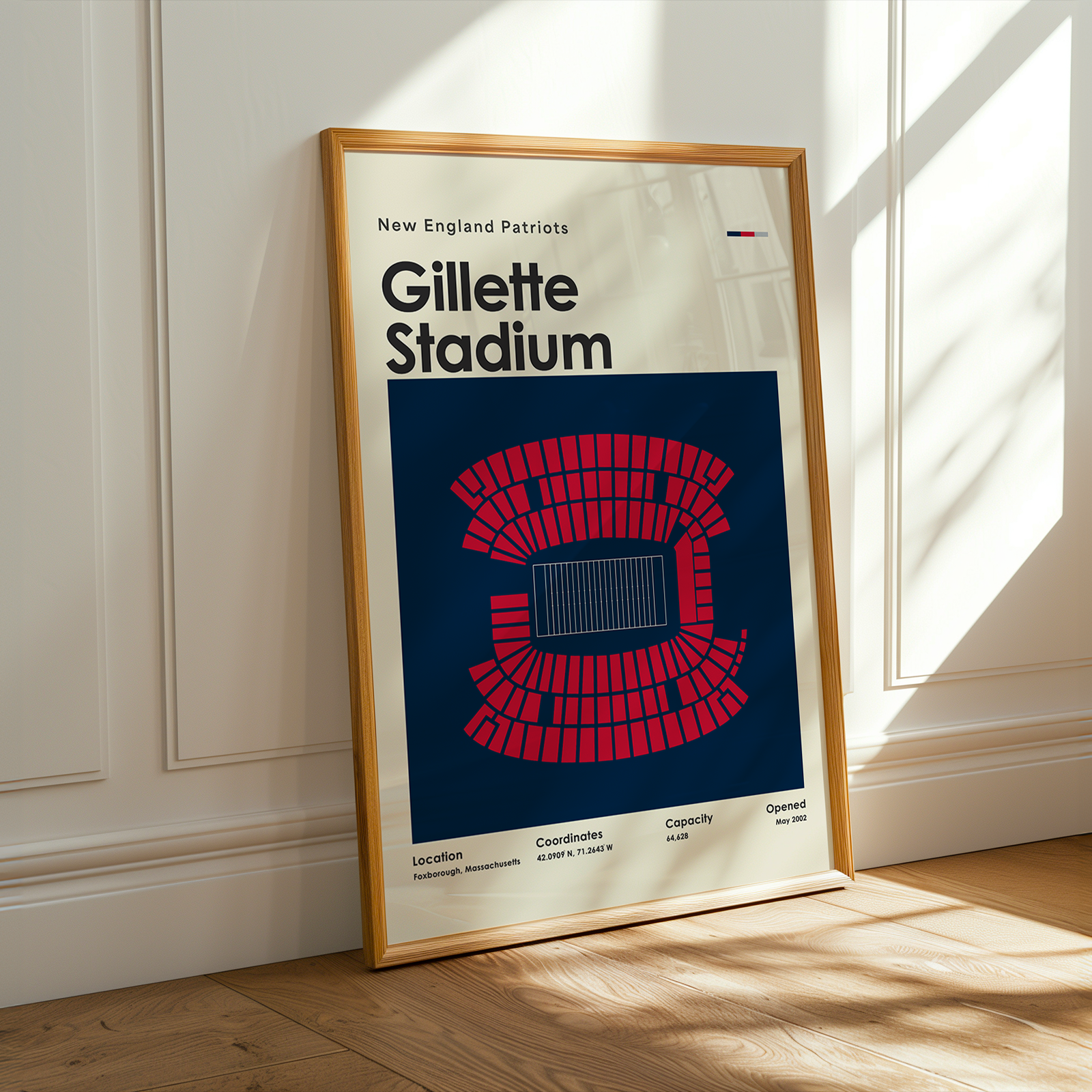 Framed poster of Gillette Stadium with New England Patriots logo on a wall.