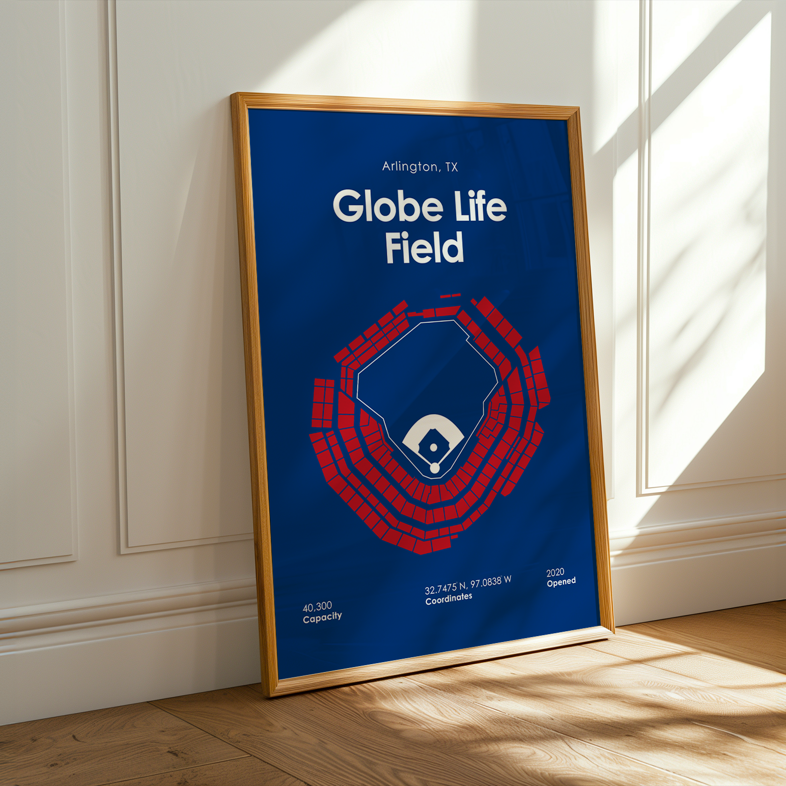 Framed poster of Globe Life Field with blue background and red design, leaning against a white wall.