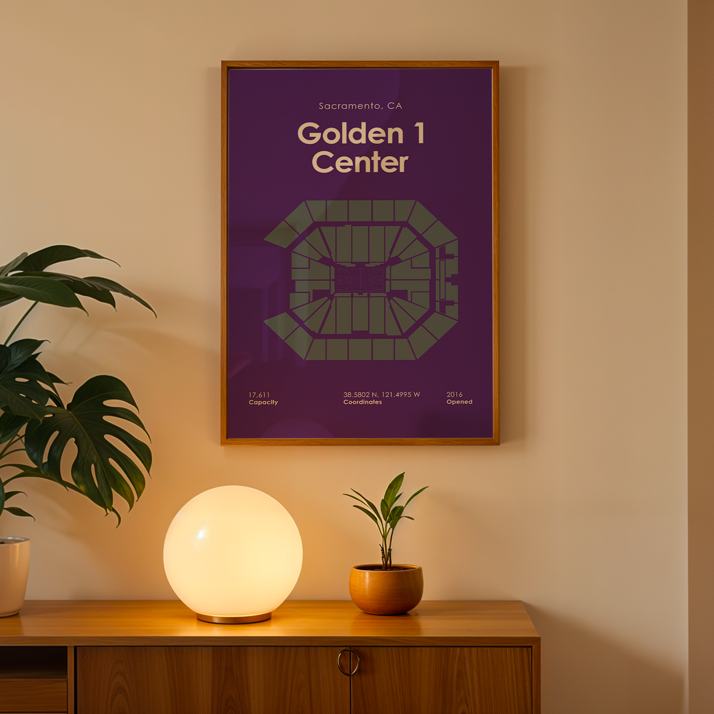 Framed map of Golden 1 Center on a wall above a wooden cabinet with decorative items.