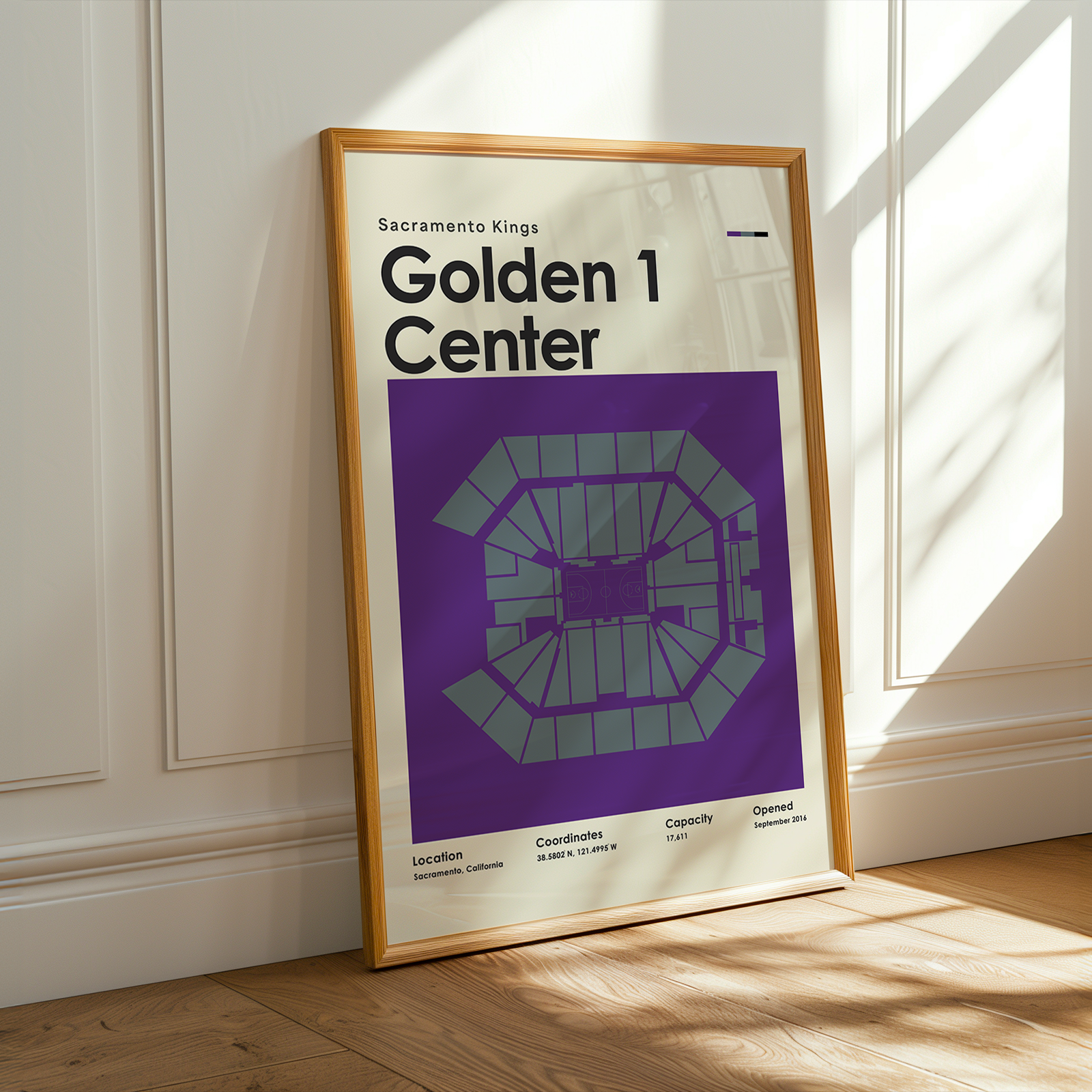 Framed poster of Golden 1 Center in a room with sunlight streaming through a window.